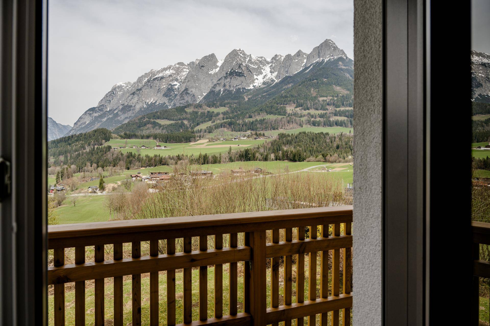 Atemberaubender Blick vom Balkon auf die majestätische Berglandschaft und grüne Täler.