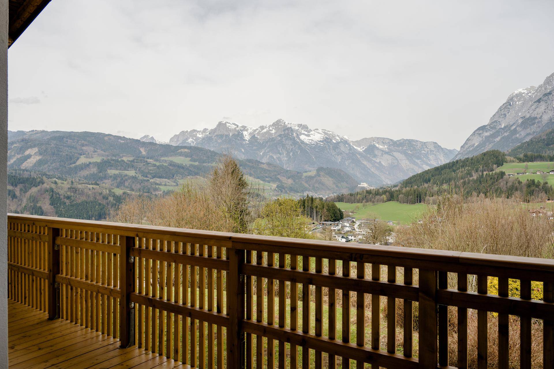 Weitläufiger Panoramablick vom Balkon über die grüne Landschaft und die umliegenden Berge.