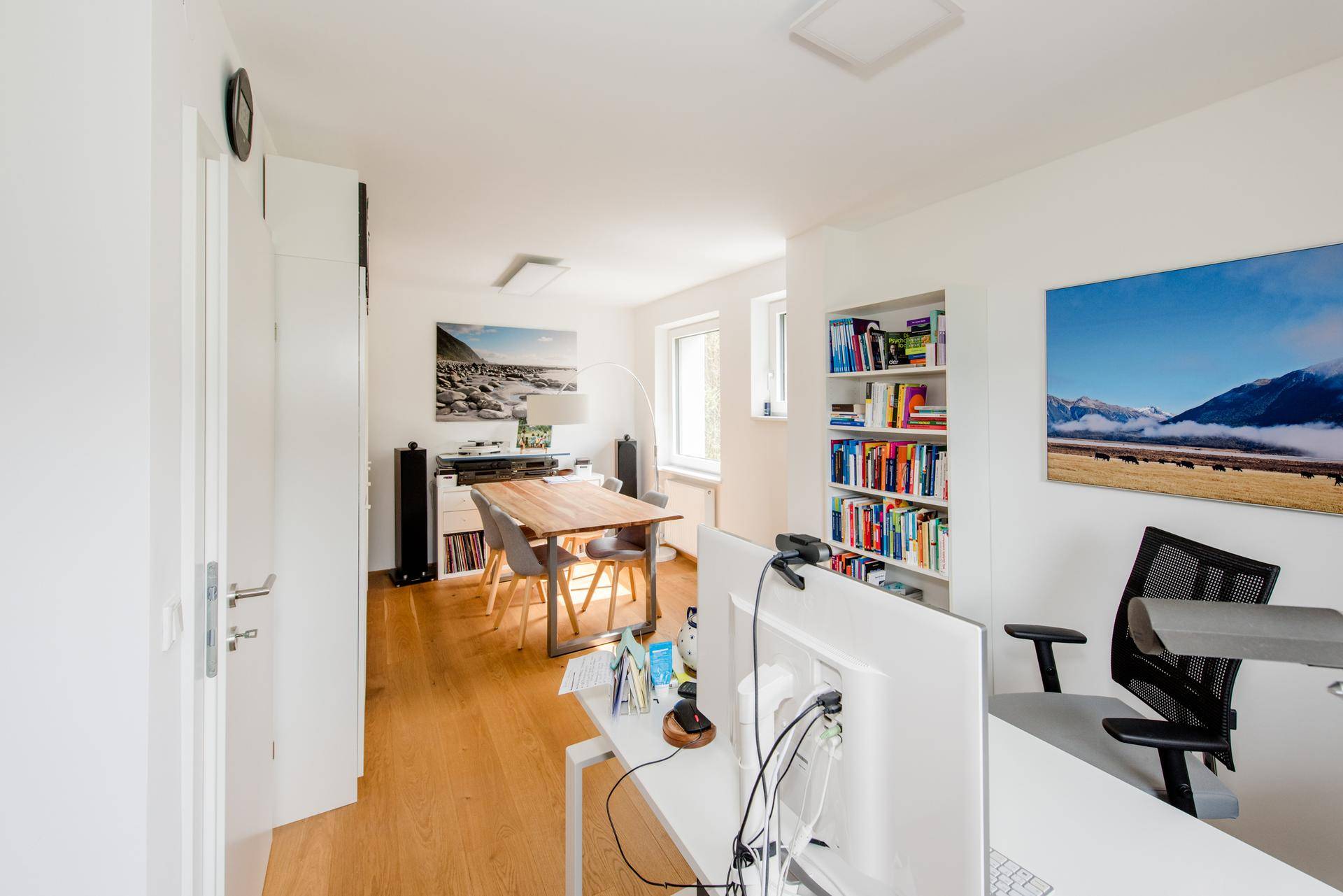 Geräumiges Arbeitszimmer mit Holzboden, Esstisch und Bücherregalen, ideal für Arbeit und Besprechungen.