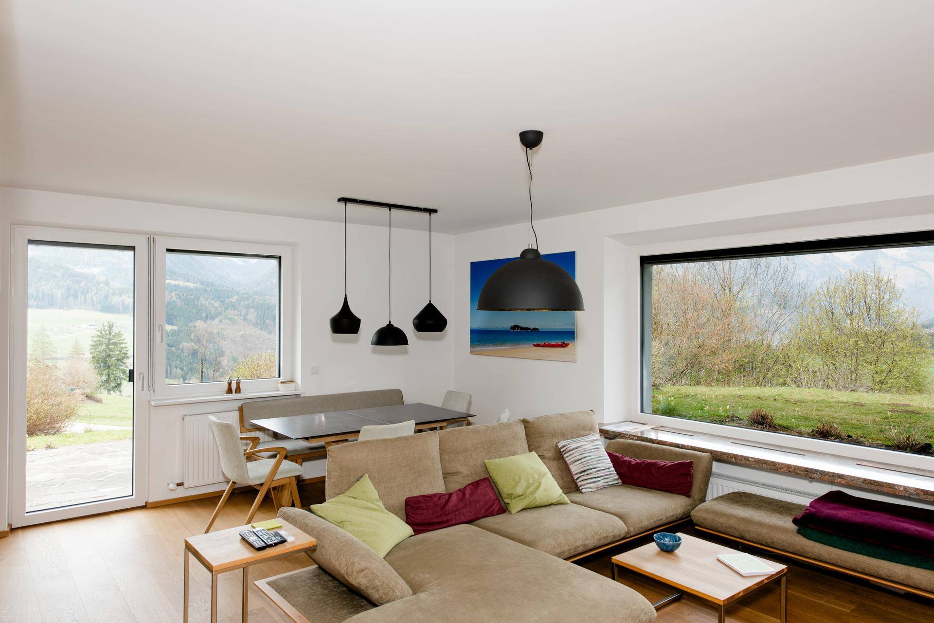 Lichtdurchfluteter Wohn-Essbereich mit großem Fenster, Balkonzugang und weitem Blick in die Natur.
