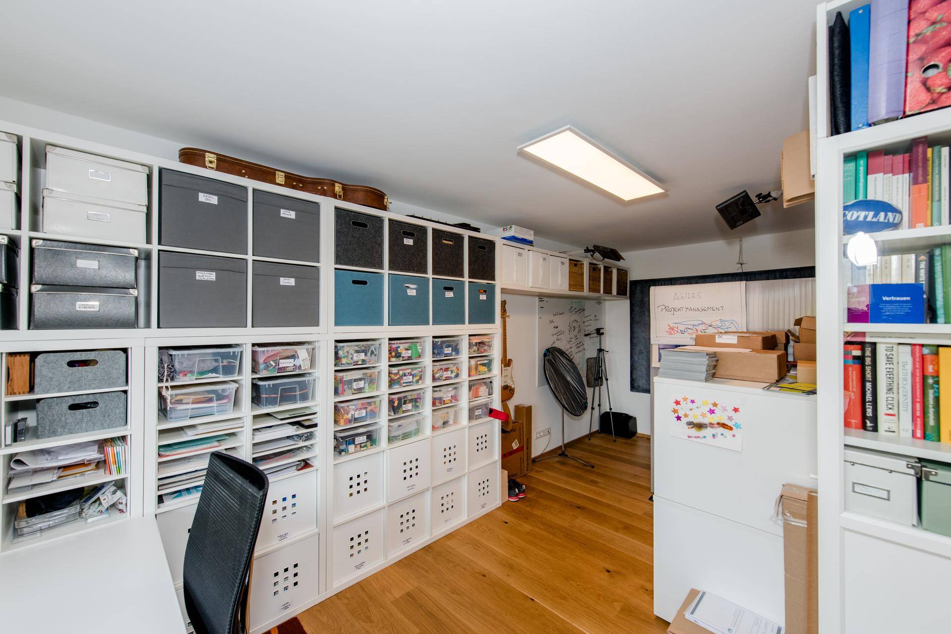 Gut organisiertes Arbeits- und Lagerzimmer mit vielen Regalen und Boxen für kreative Projekte.