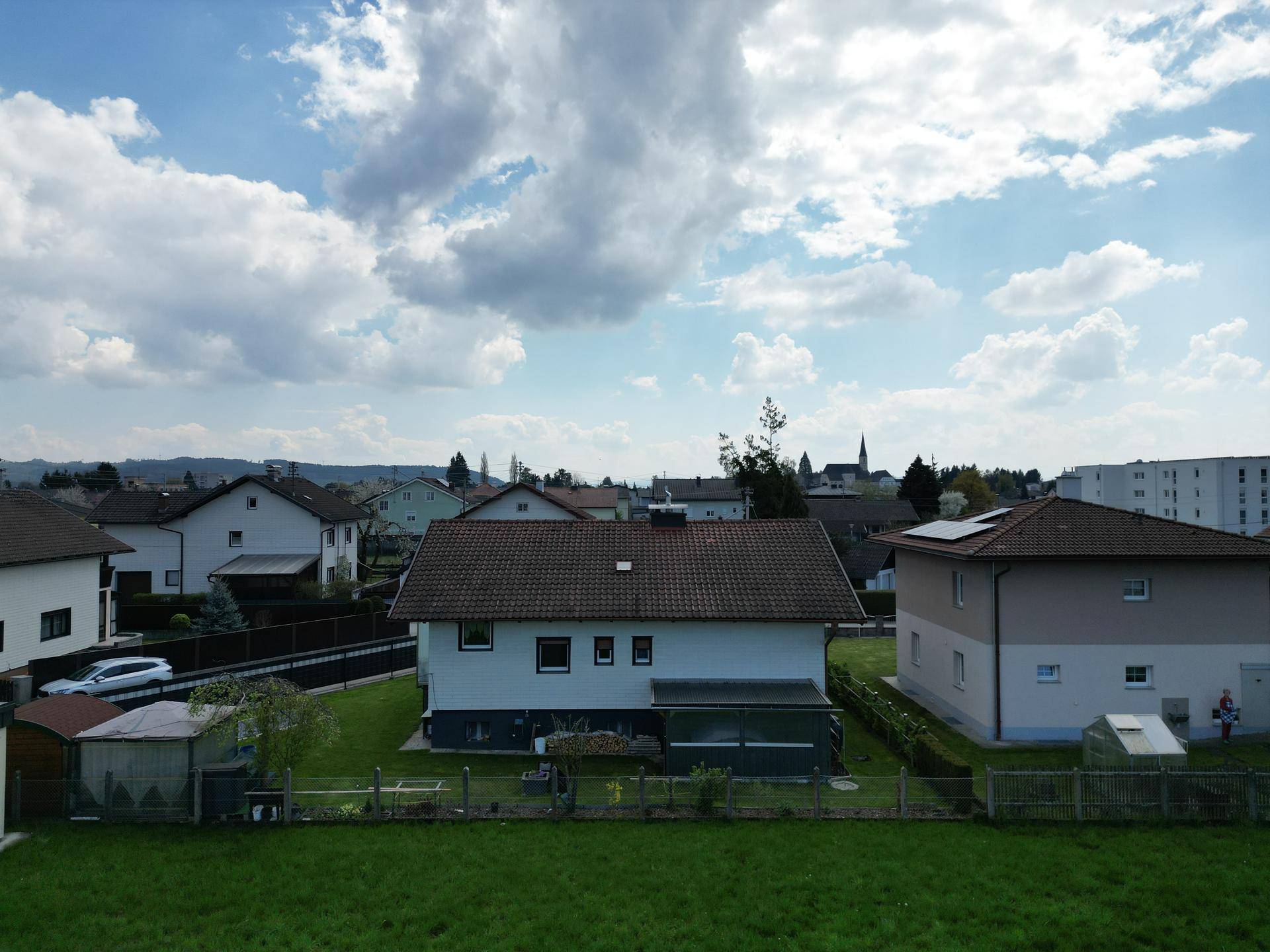 Panoramablick aus der Luft auf eine Wohnsiedlung mit Einfamilienhäusern und Gärten.
