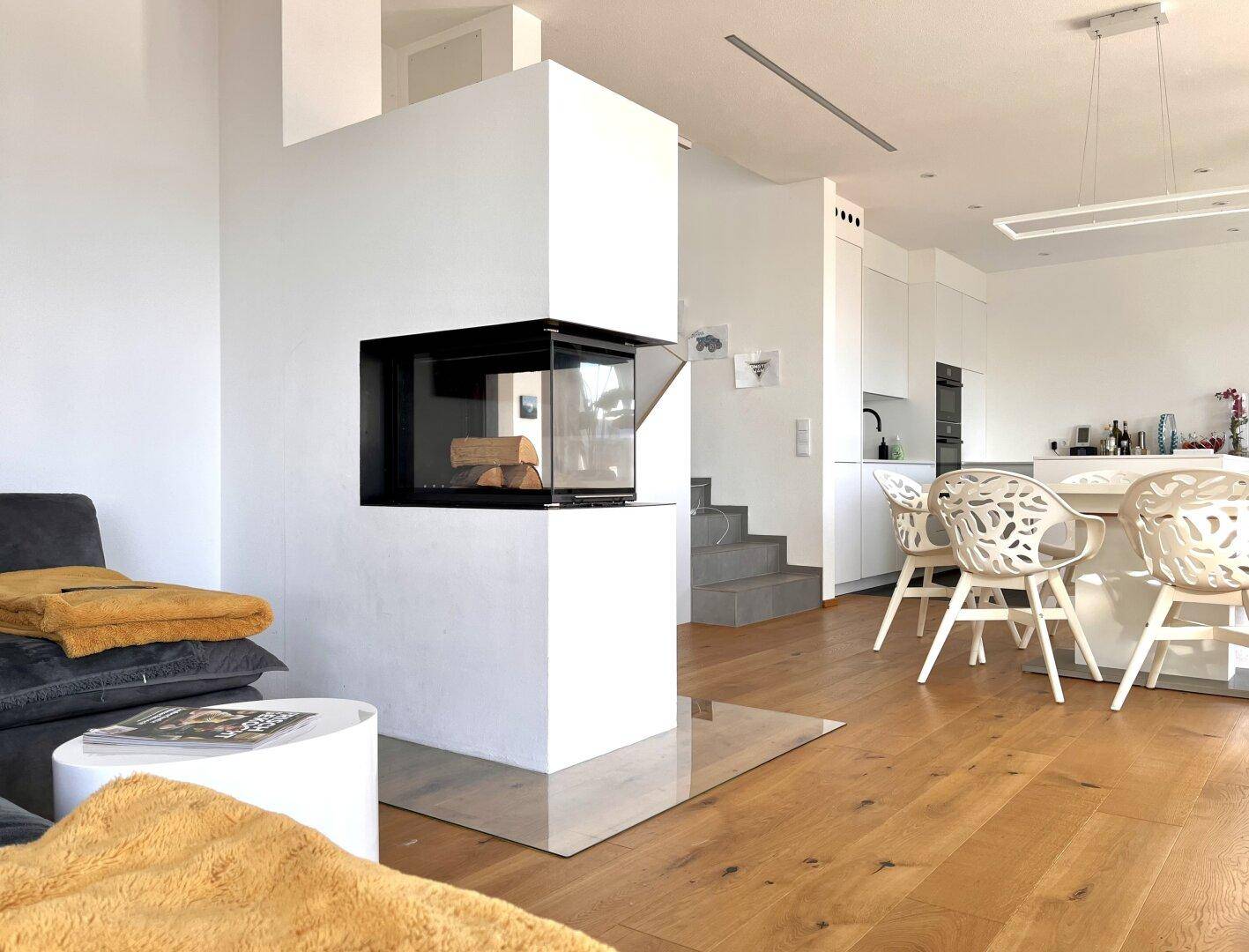 Gemütlicher Wohnbereich mit modernem Kamin, Holzboden und offener Gestaltung.