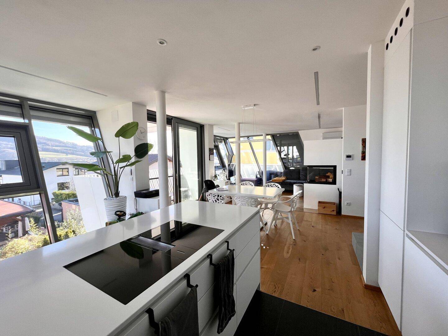 Offener Wohn- und Essbereich mit moderner Küche, Kamin und Panoramablick.