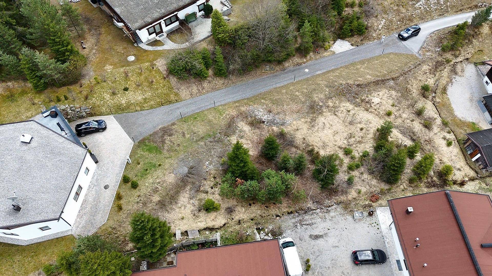 Luftaufnahme eines Grundstücks mit umliegenden Häusern und einer Zufahrtsstraße in ländlicher Umgebung.