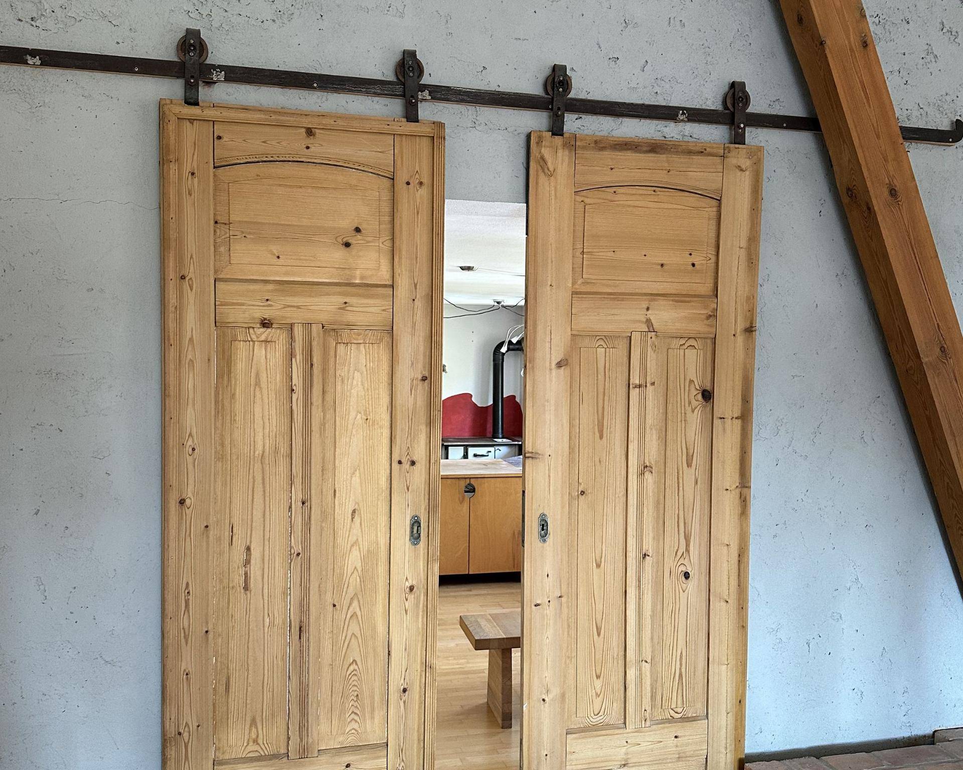 Rustikale Holzschiebetüren im Scheunenstil mit sichtbaren Beschlägen und integrierten Spiegeln.
