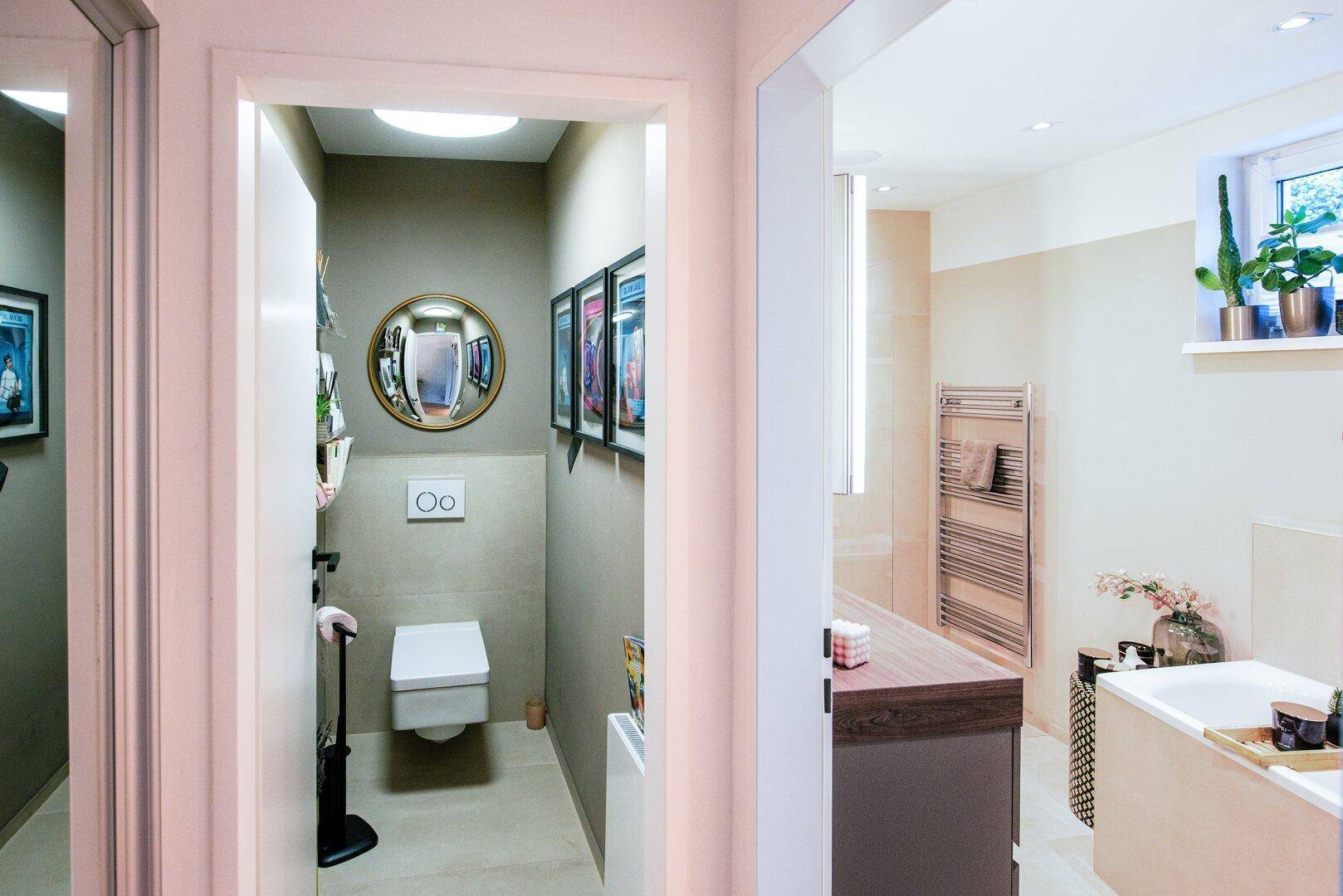 Modernes Gäste-WC mit wandhängender Toilette und kleinem Waschbecken, angrenzend an ein Badezimmer.