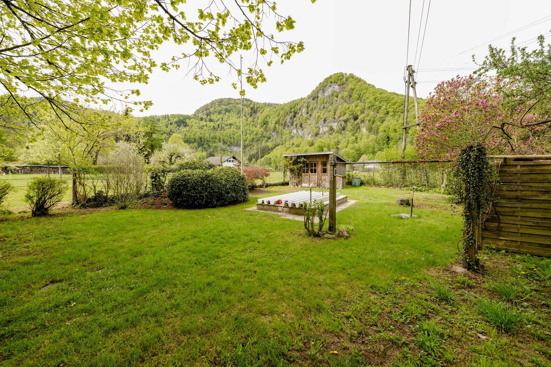 Weitläufiger Gartenbereich mit Gartenhaus und beeindruckendem Blick auf die umliegenden Berge.