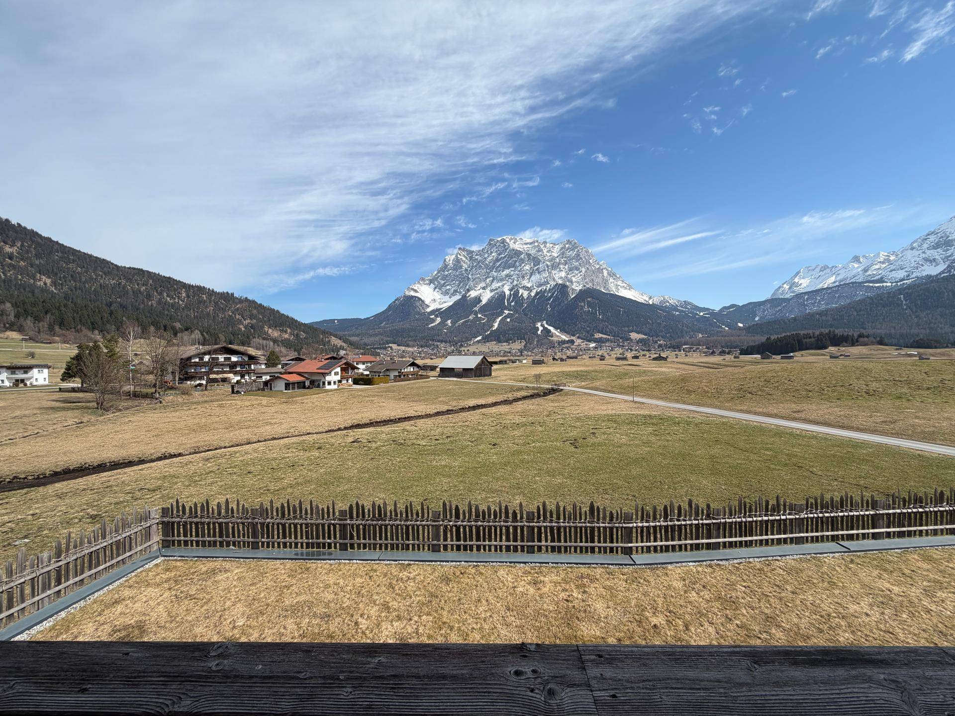 Malerischer Ausblick auf die Bergwelt und grüne Wiesen von der erhöhten Position des Grundstücks.