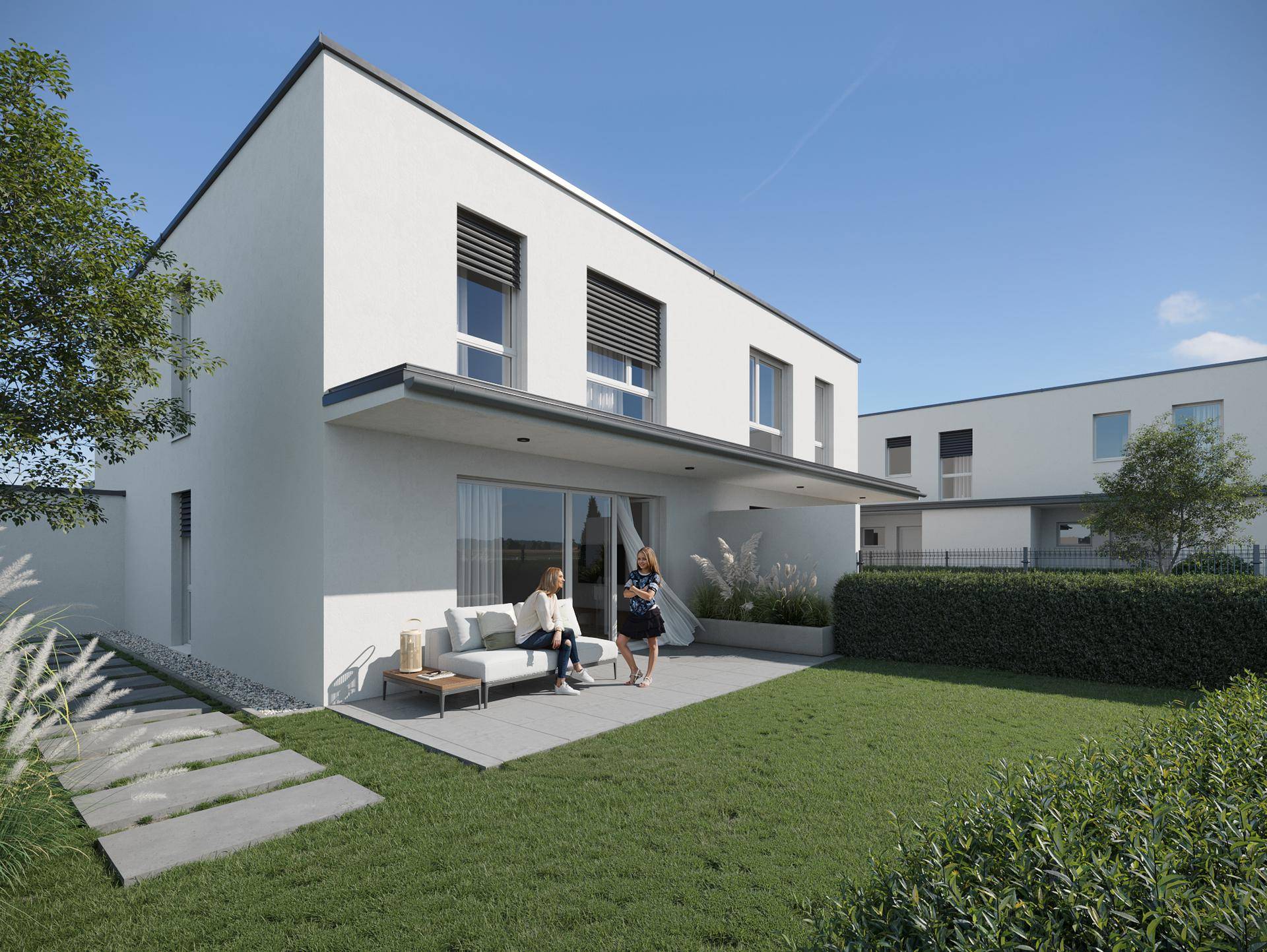 Sonniger Außenbereich mit Terrasse, Rasenfläche und moderner Fassade des Hauses.