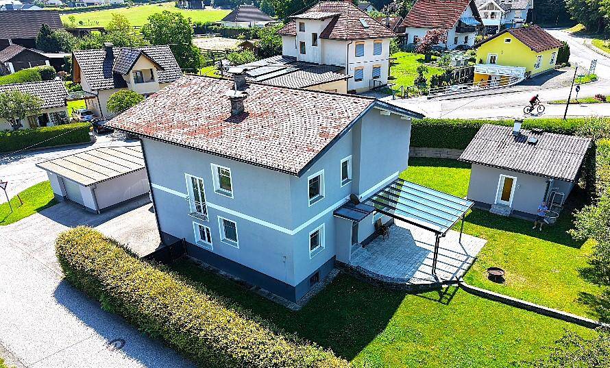 Vogelperspektive eines Hauses mit großem Garten, Garage und ländlicher Umgebung.