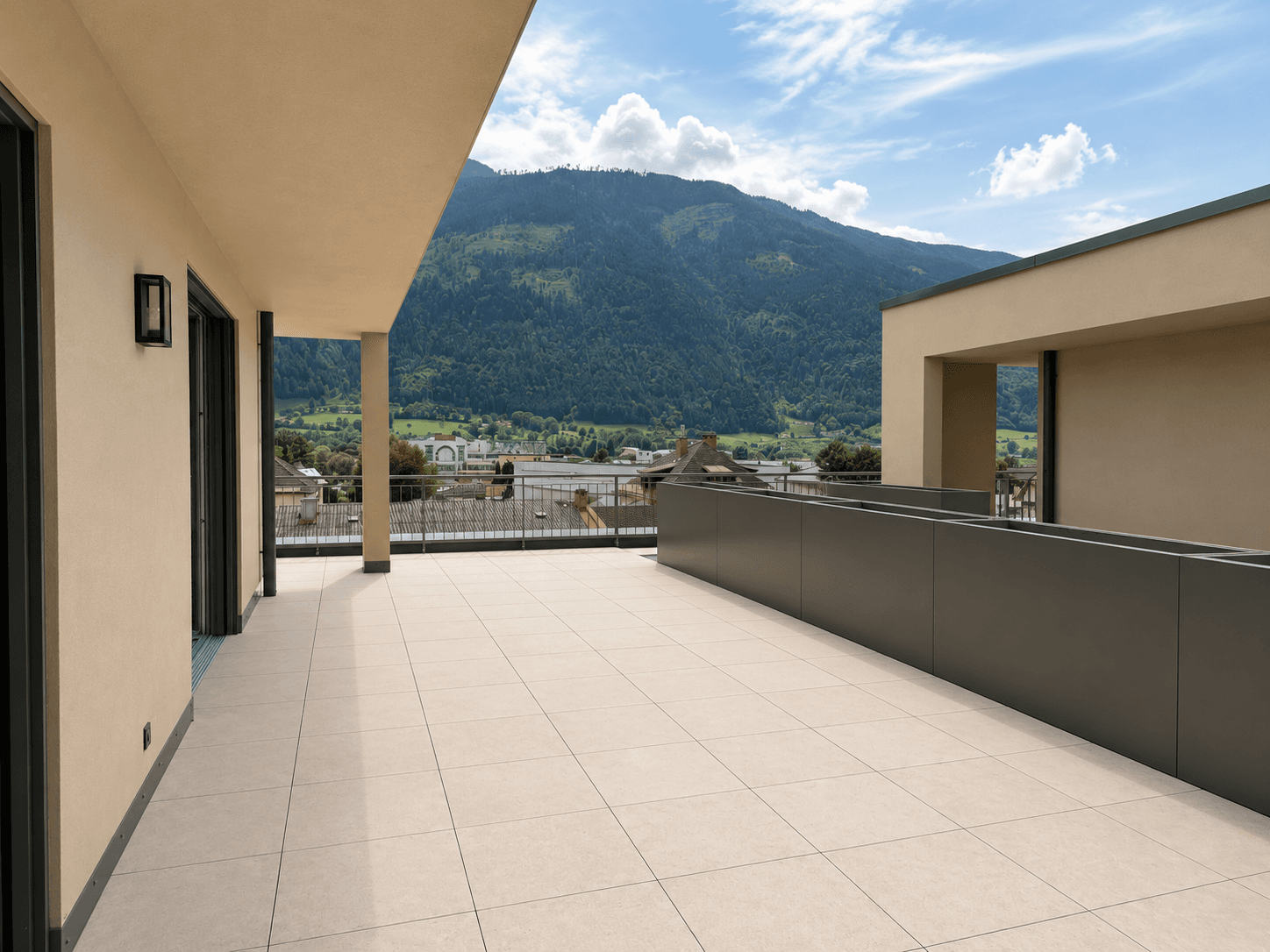 Große, geflieste Terrasse mit weitem Bergblick und viel Platz für Outdoor-Möbel unter blauem Himmel.