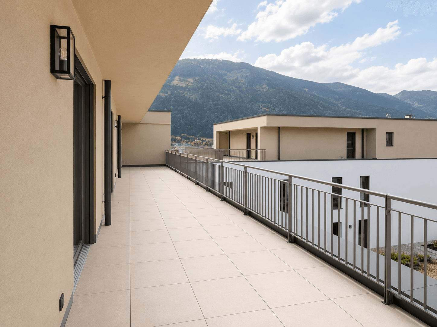 Geräumige Terrasse mit Metallgeländer und Panoramablick auf die umliegende Berglandschaft.