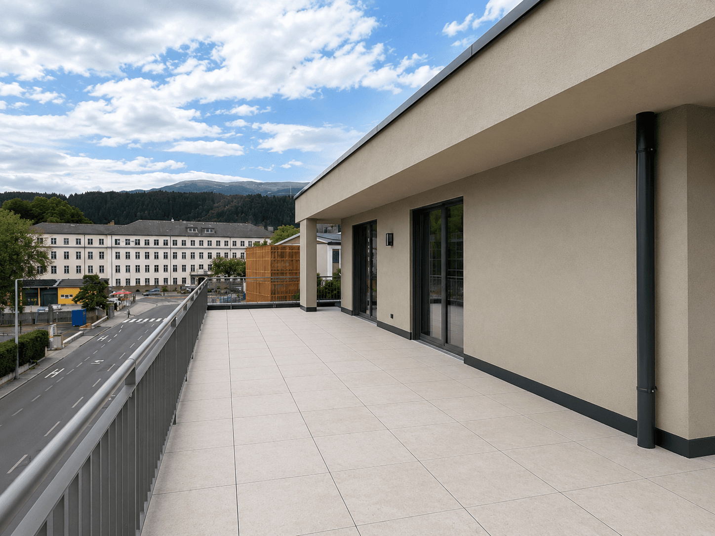 Geräumige Dachterrasse mit Fliesenboden und weitem Blick über die Stadt und die Berge.