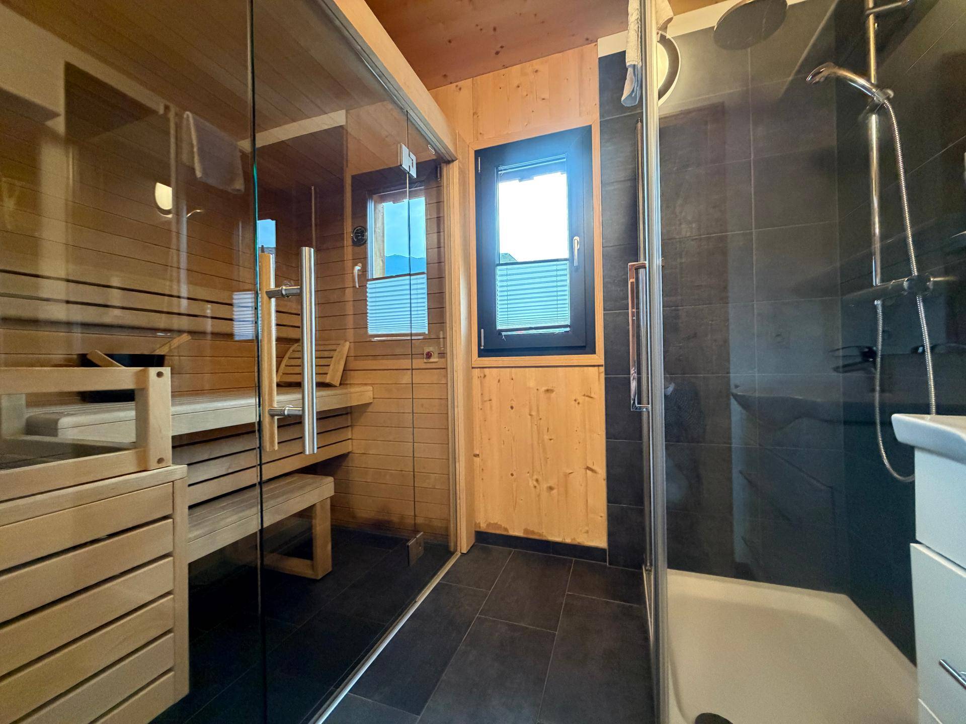 Modernes Badezimmer mit Sauna, begehbarer Dusche und Holzwänden.