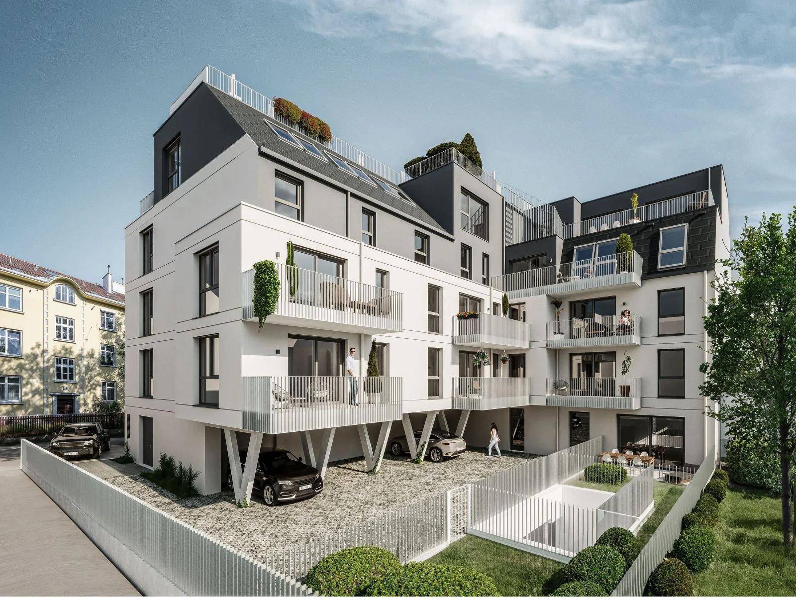Rückansicht eines modernen Wohngebäudes mit mehreren Balkonen, Tiefgaragenzufahrt und Grünflächen.