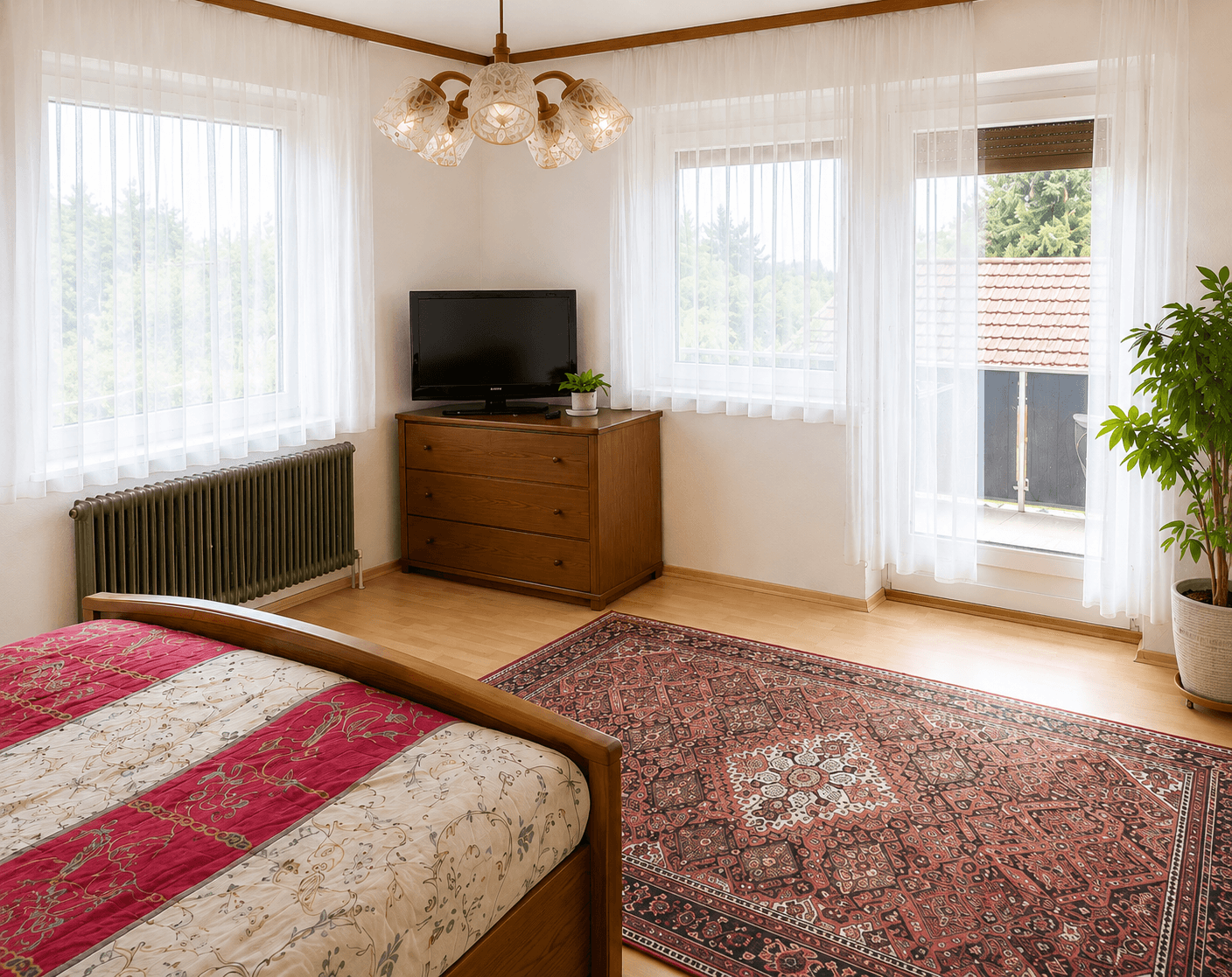 Schlafzimmer mit großem Fenster, Kommode und traditionellem Teppich.