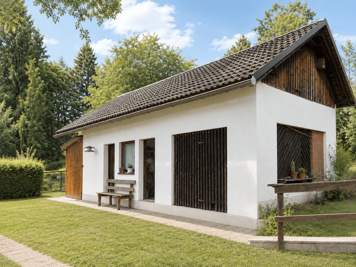 Kleines Nebengebäude im Garten mit Holzverkleidung und Sitzbank.