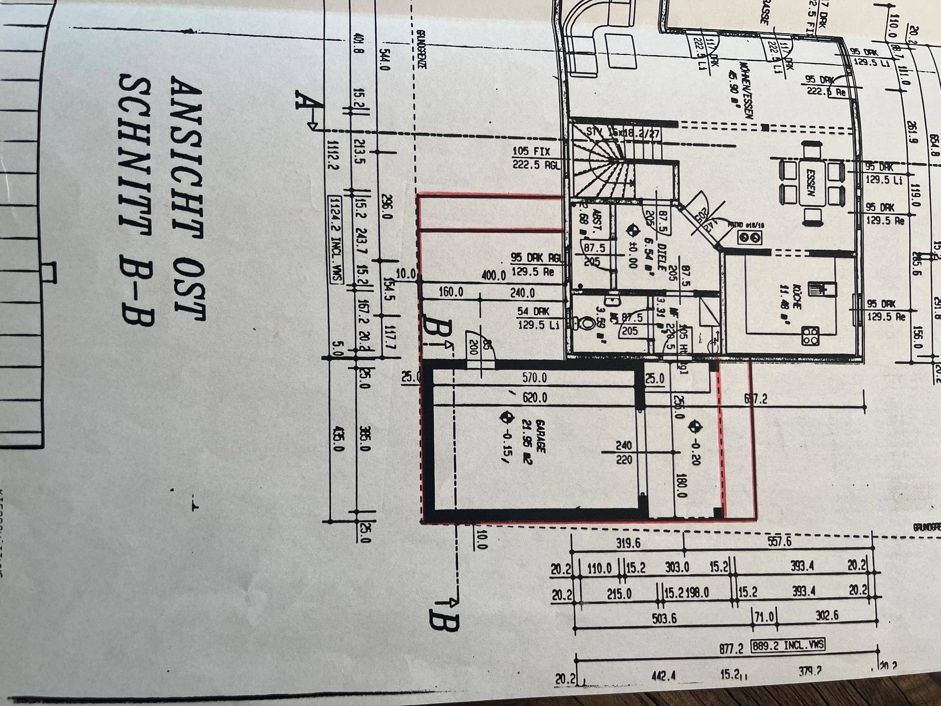 Grundriss des Erdgeschosses mit offenem Wohnbereich, Küche, Esszimmer und integrierter Garage.