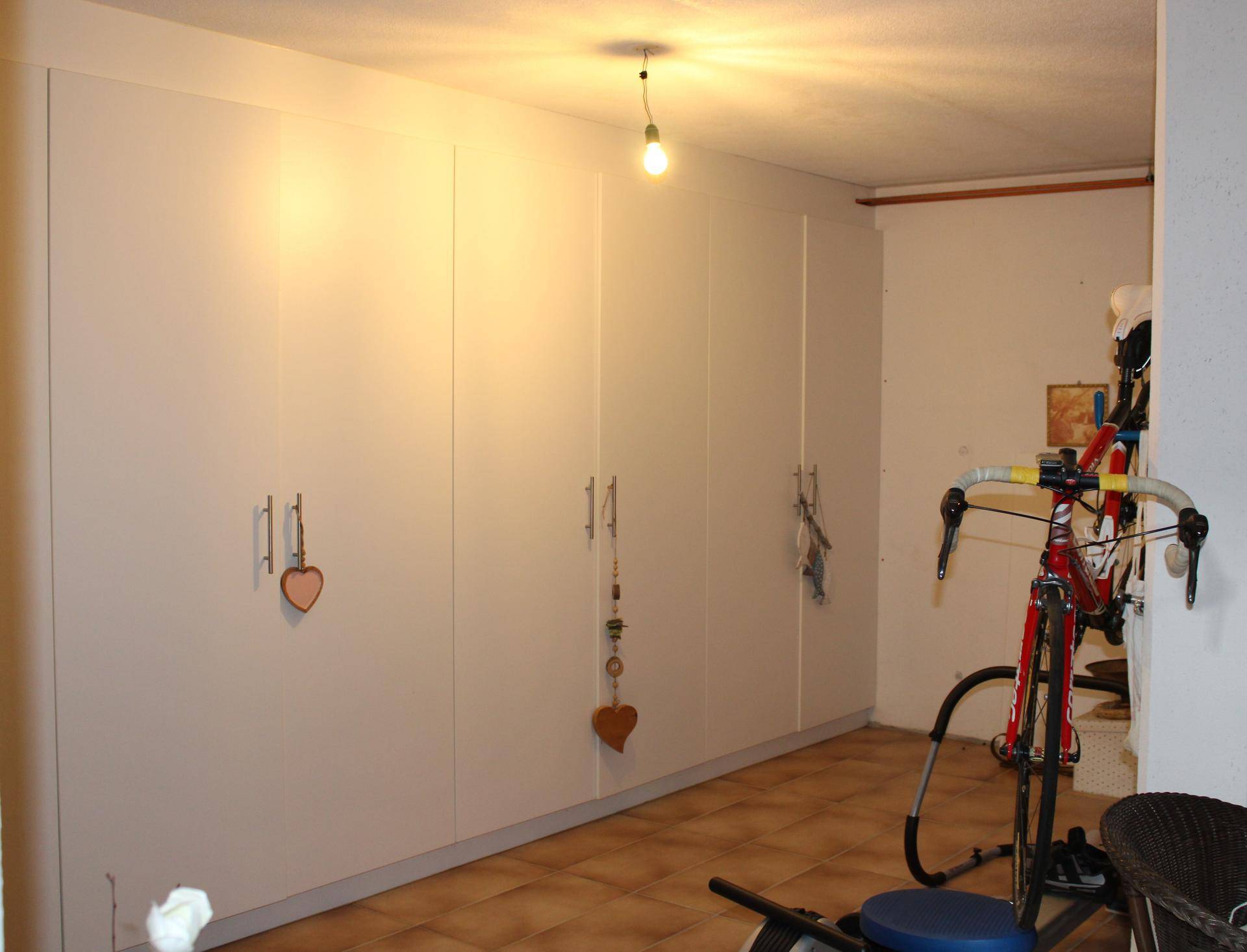 Praktischer Abstellraum mit Einbauschränken und Platz für Fahrräder.
