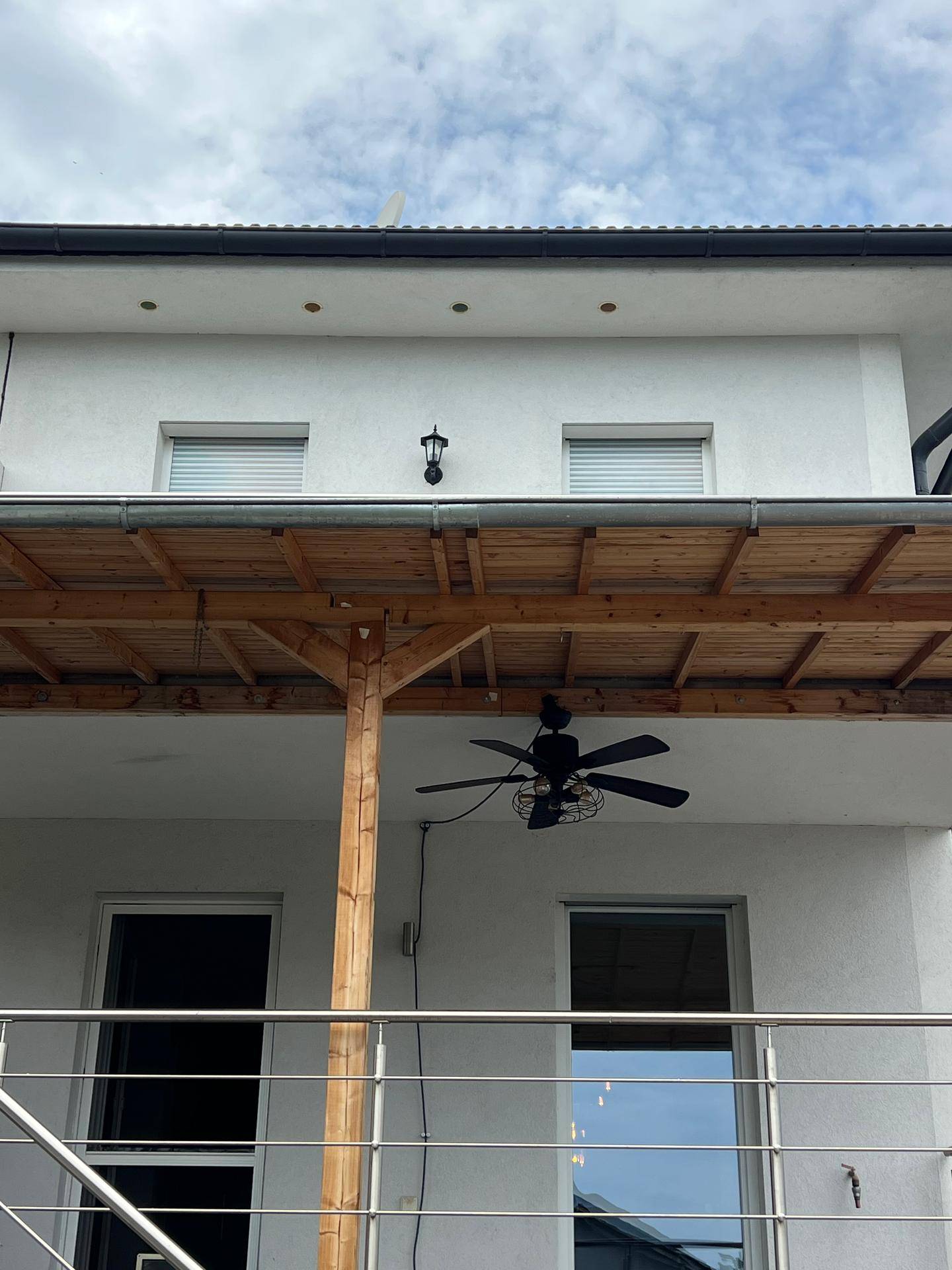Überdachter Balkon mit Holzdecke und Deckenventilator für angenehme Kühlung.