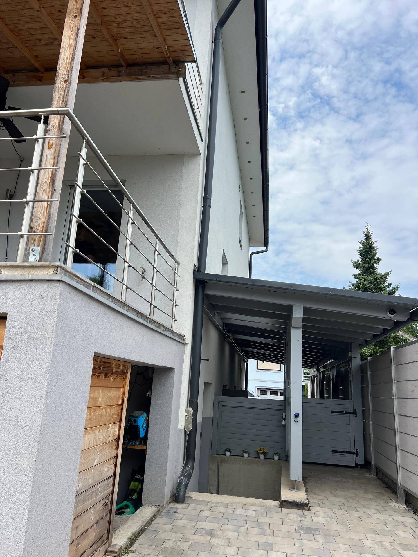 Seitenansicht des Hauses mit überdachtem Carport und Zugang zum Balkon.
