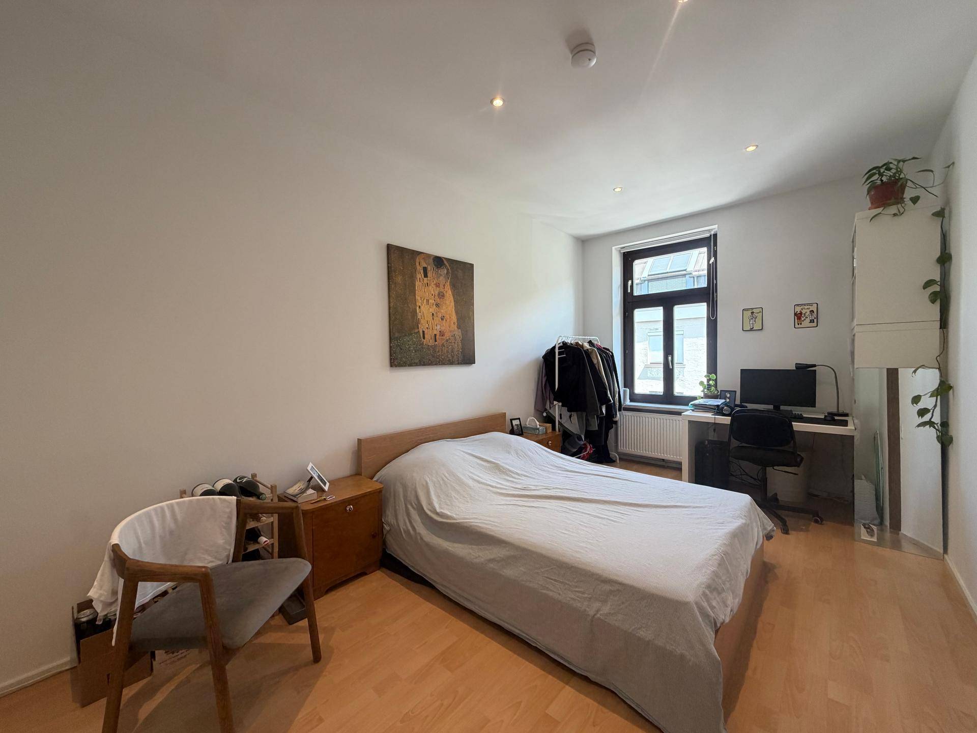 Helles Schlafzimmer mit Holzboden, Fenster und ausreichend Platz für persönliche Gestaltung.