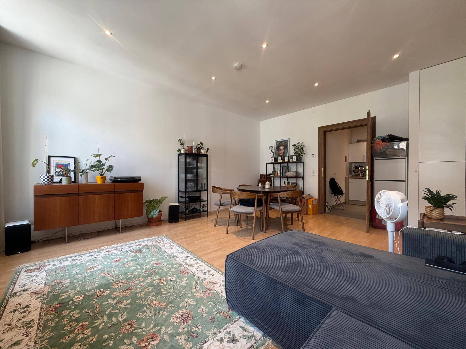 Heller Wohn-Essbereich mit Parkettboden, stilvollem Sideboard und Blick in die angrenzende Küche.