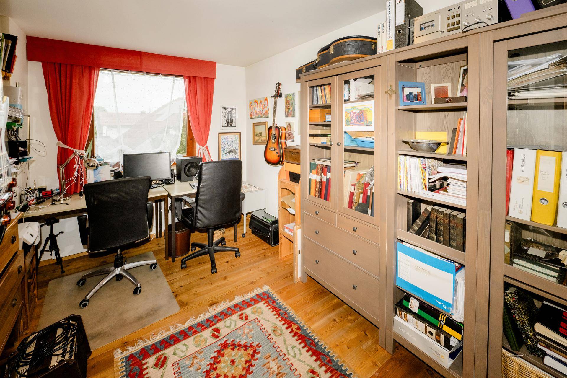 Funktionales Büro mit zwei Schreibtischen, Bücherregalen und Holzboden, ideal für Home-Office.