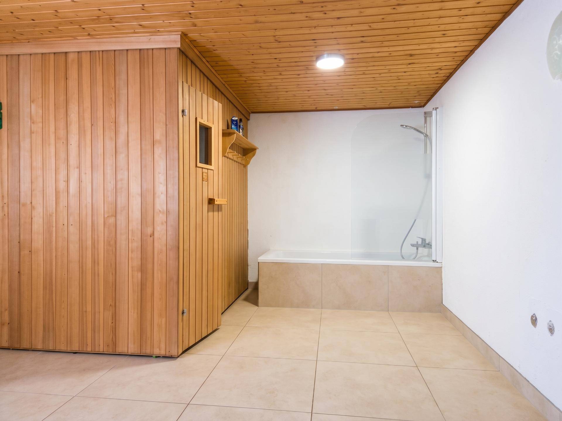 Wellnessbereich im Untergeschoss mit Sauna, Badewanne und Dusche.