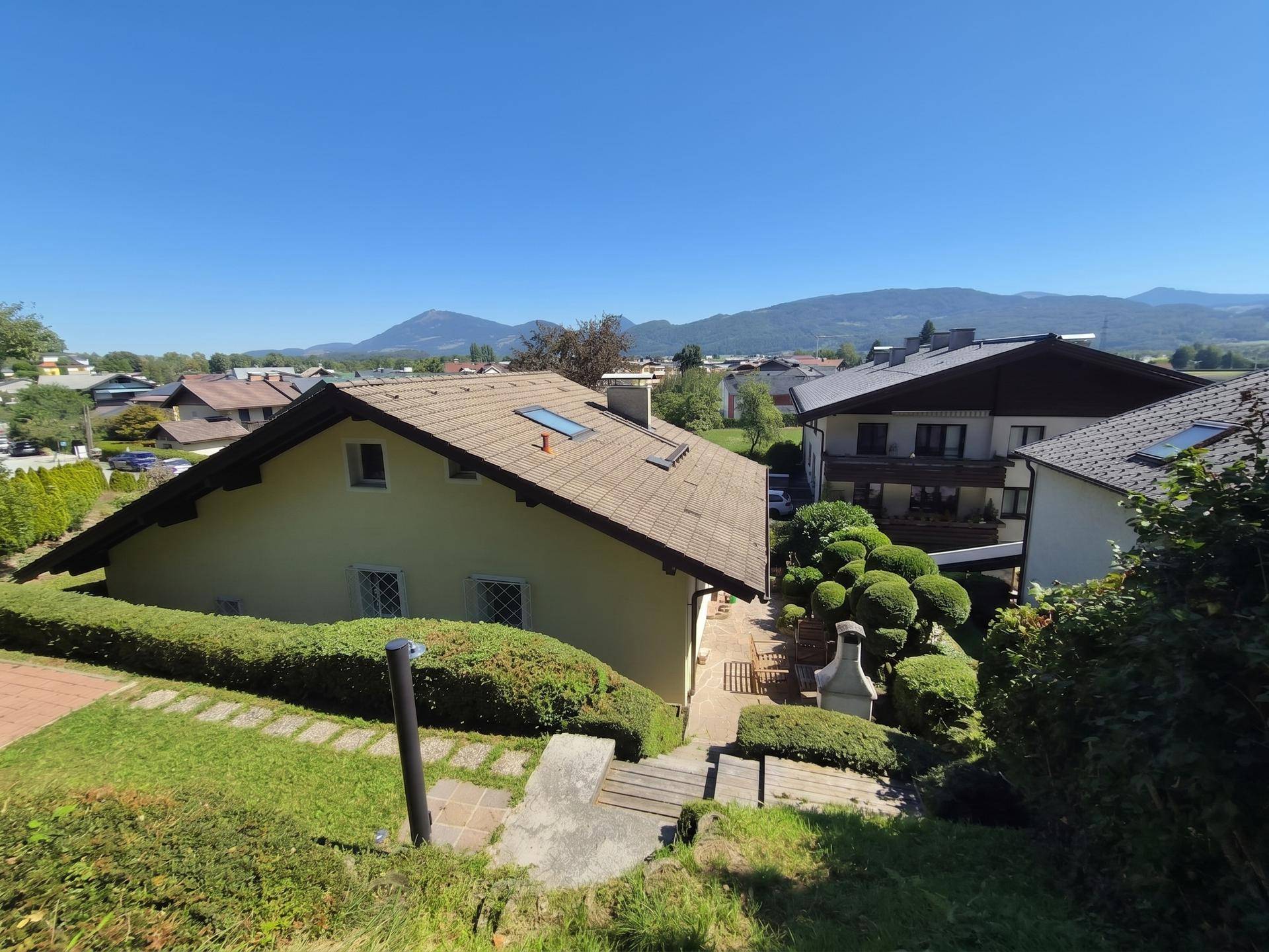 Rückansicht des Hauses mit Garten, Treppe und weitem Blick auf die Landschaft.