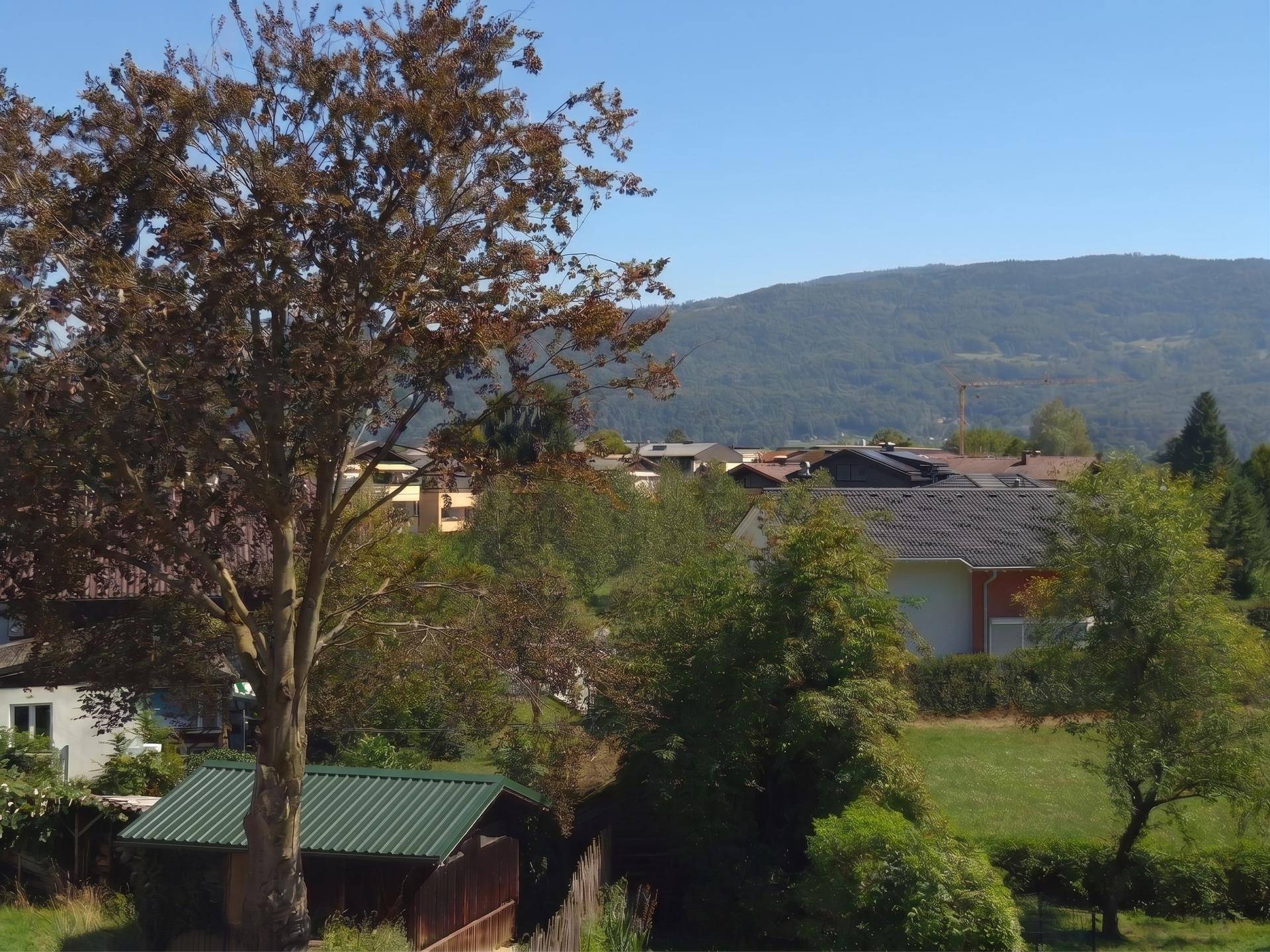Weitläufiger Blick auf die grüne Landschaft und die umliegenden Berge.