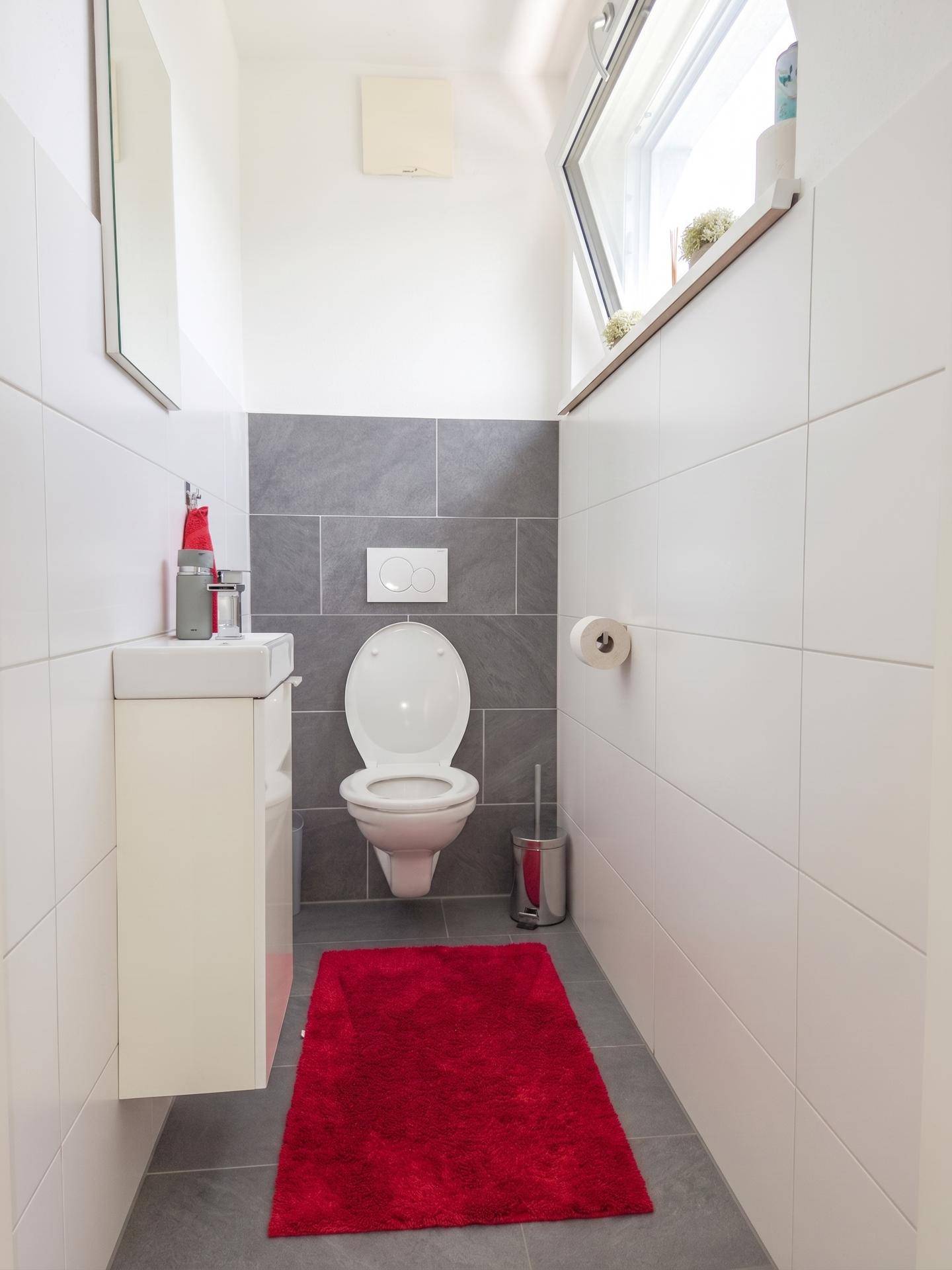 Modernes Gäste-WC mit Wand-WC, kleinem Waschbecken und Fenster.