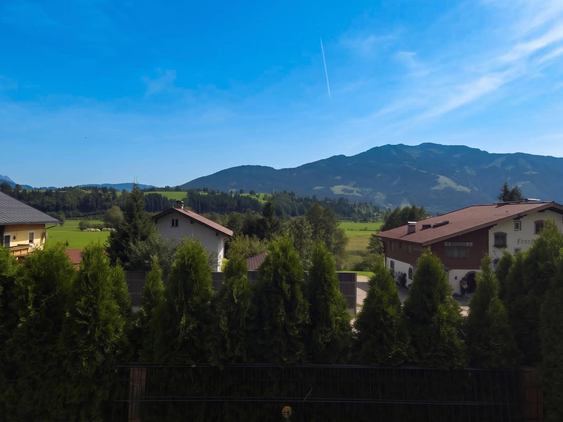 Weitläufiger Blick auf die grüne Landschaft und die umliegenden Berge.