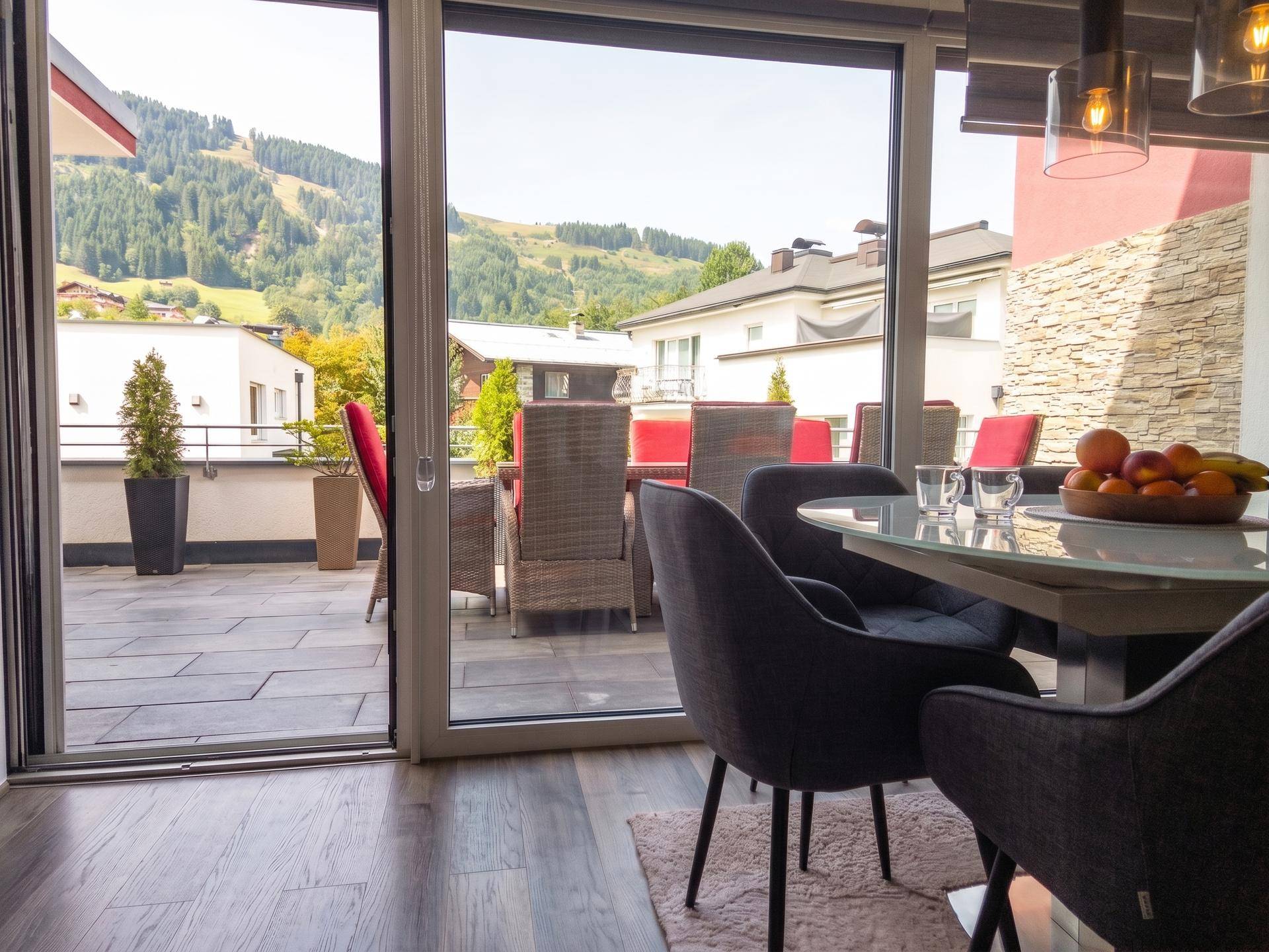 Essbereich mit Zugang zur Terrasse und weitem Blick auf die umliegende Berglandschaft.