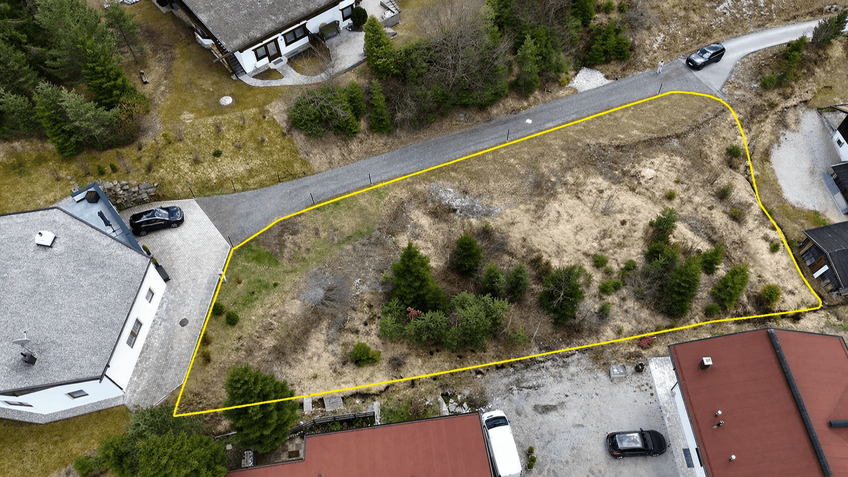 Übersicht des unbebauten Grundstücks aus der Vogelperspektive mit angrenzenden Straßen und Häusern.