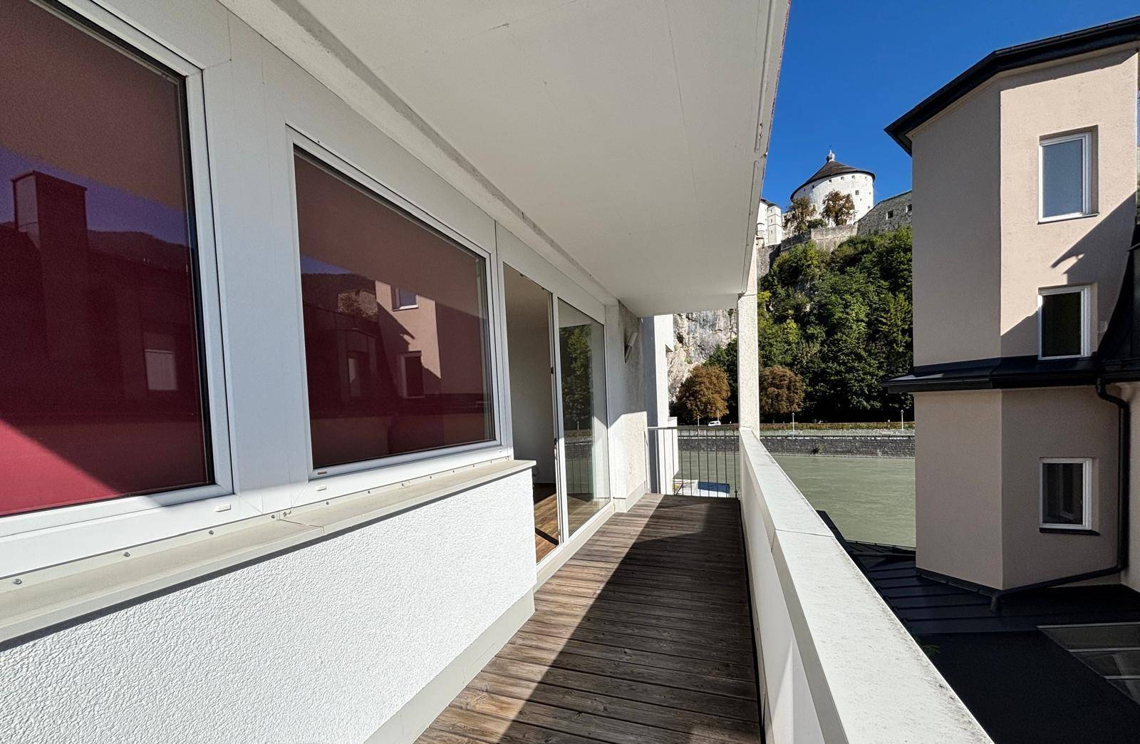 Geräumiger Balkon mit Holzboden und weitem Blick auf den Fluss und die historische Festung.