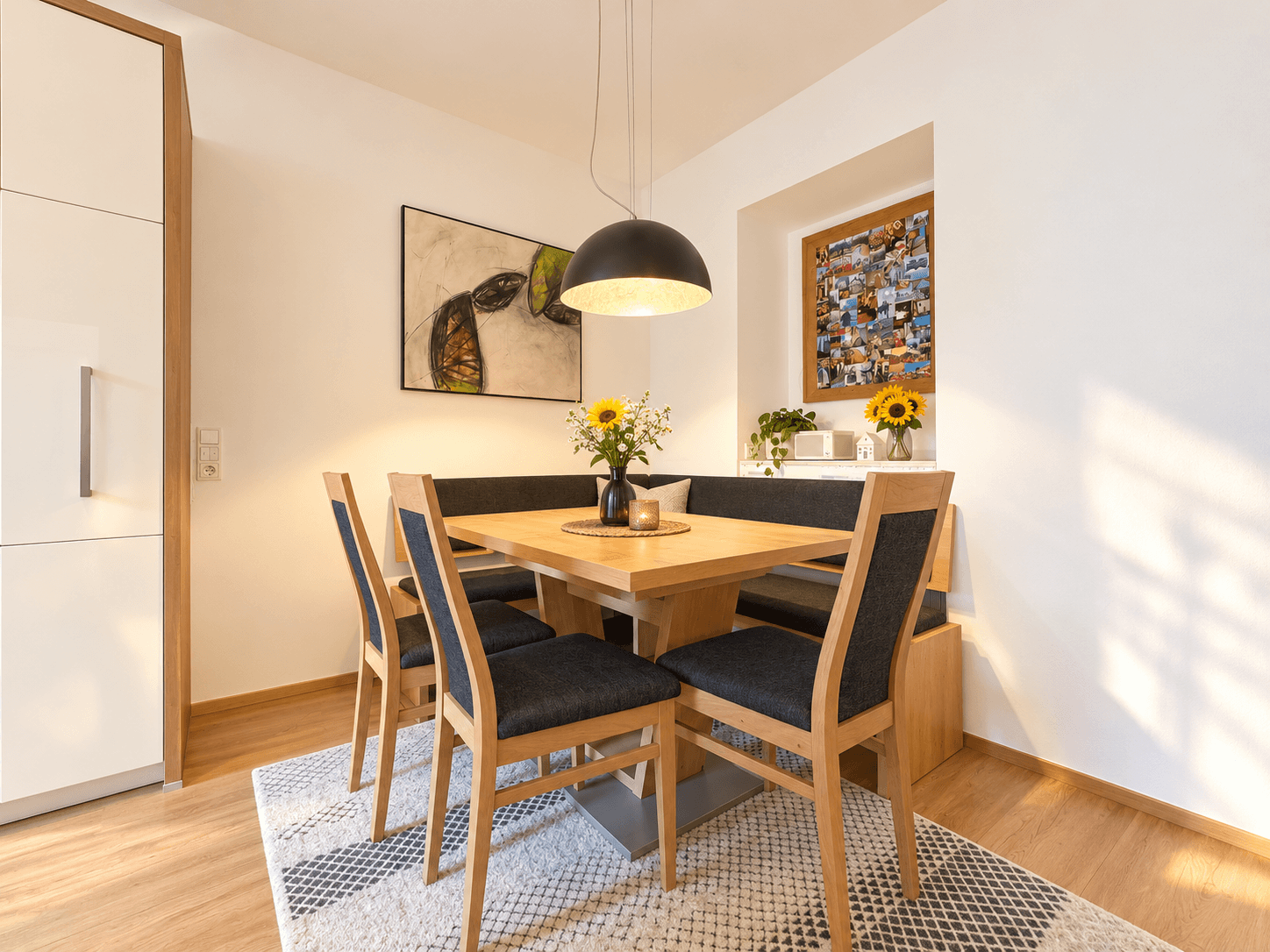 Gemütlicher Essbereich mit Eckbank und Holztisch, beleuchtet von einer modernen Pendelleuchte.