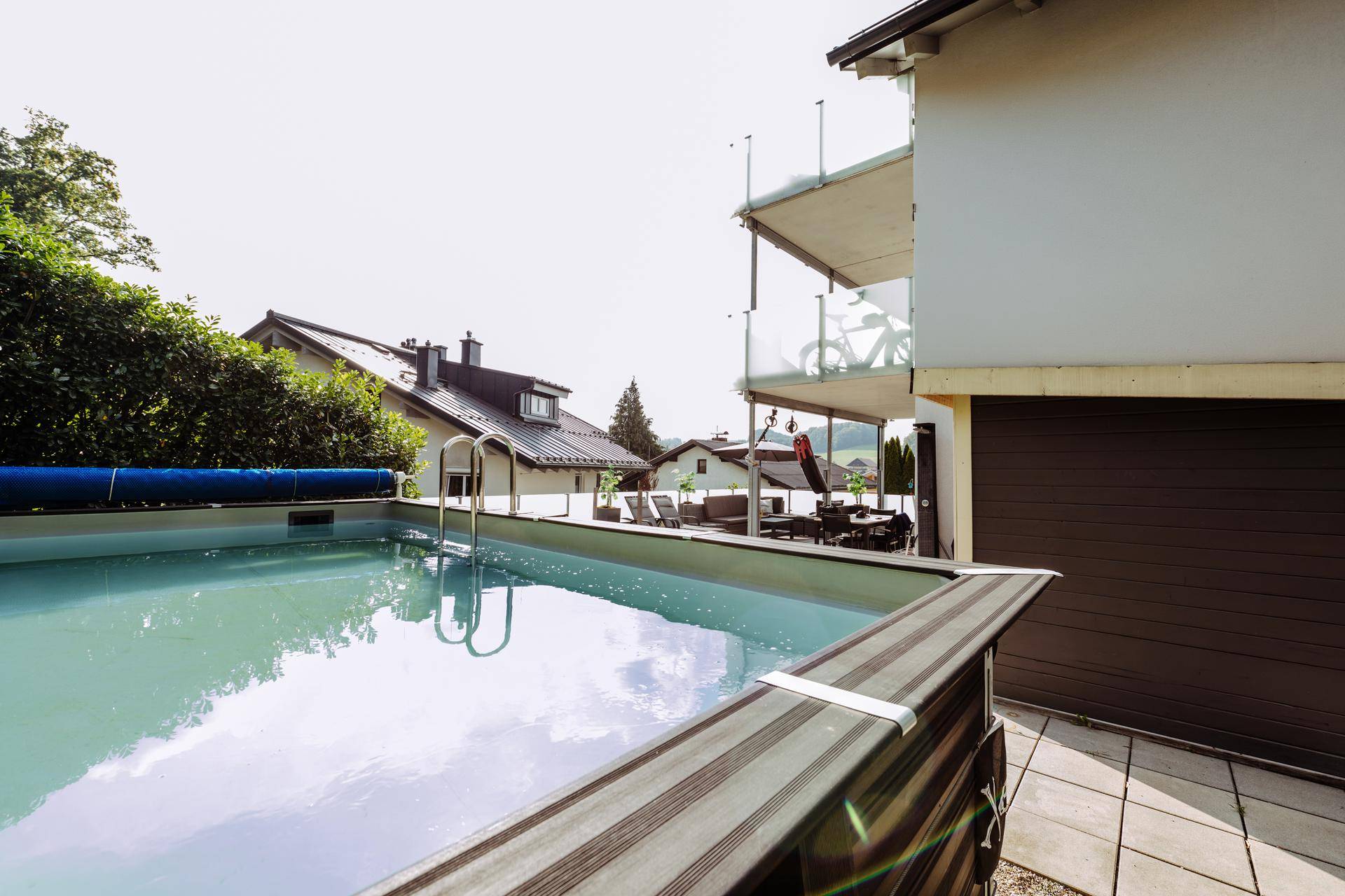 Außenbereich mit einem oberirdischen Pool und Blick auf die umliegende Wohngegend.