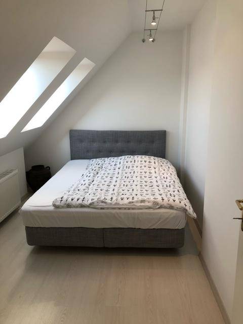 Gemütliches Schlafzimmer im Dachgeschoss mit Dachfenstern und modernem Bett.