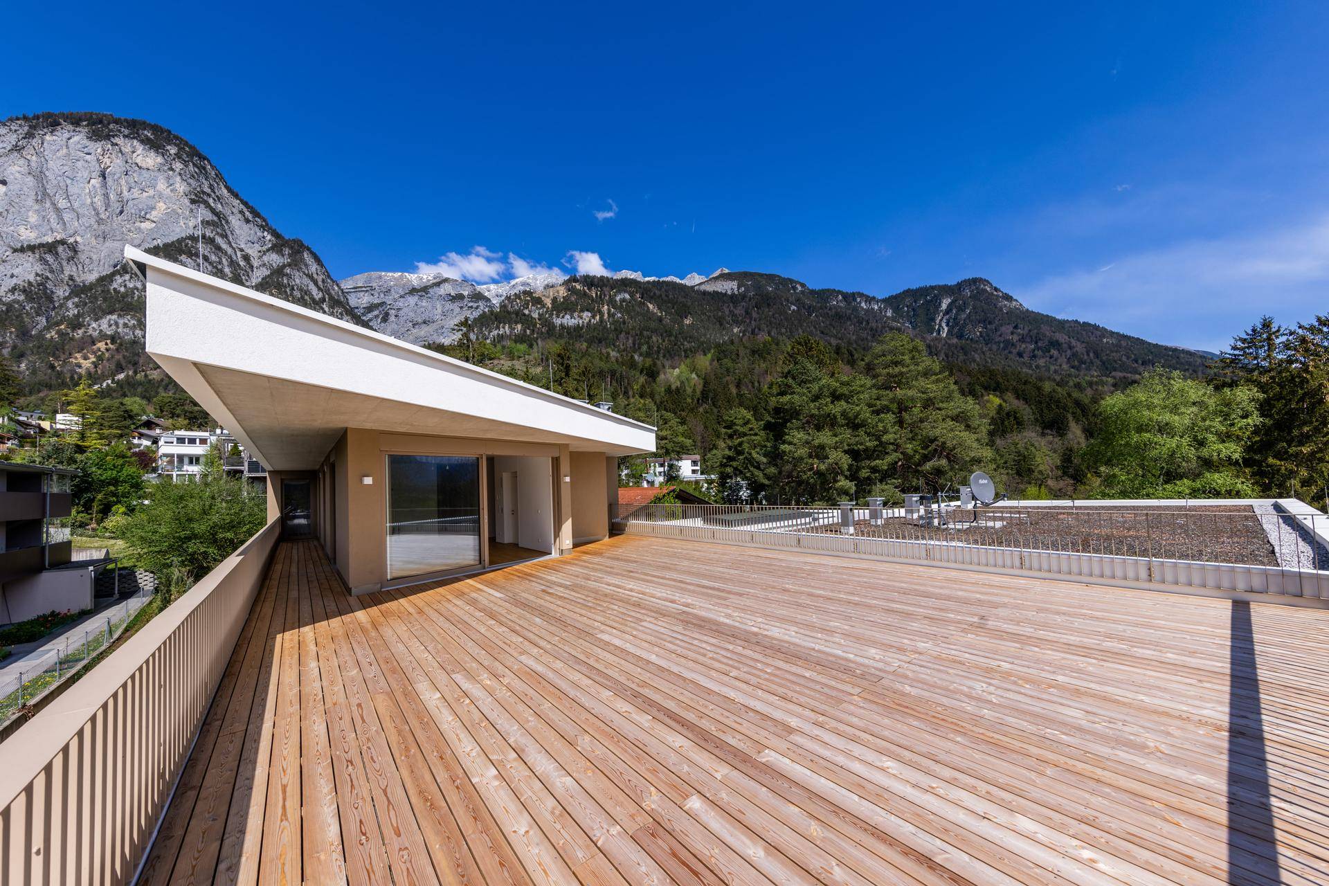 Große Dachterrasse mit Holzboden und atemberaubendem Blick auf die umliegende Berglandschaft.