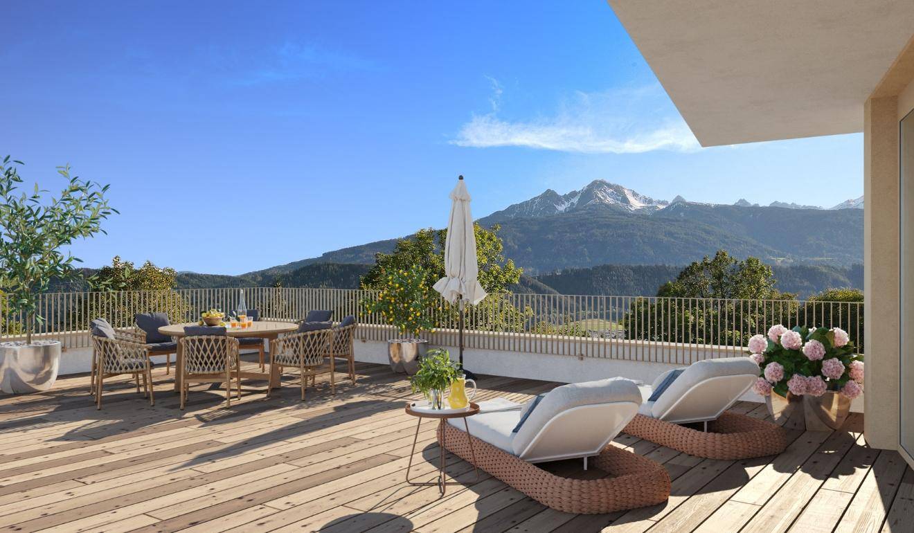 Geräumige Dachterrasse mit Sitzgelegenheiten und Liegen, bietet einen weiten Bergblick.