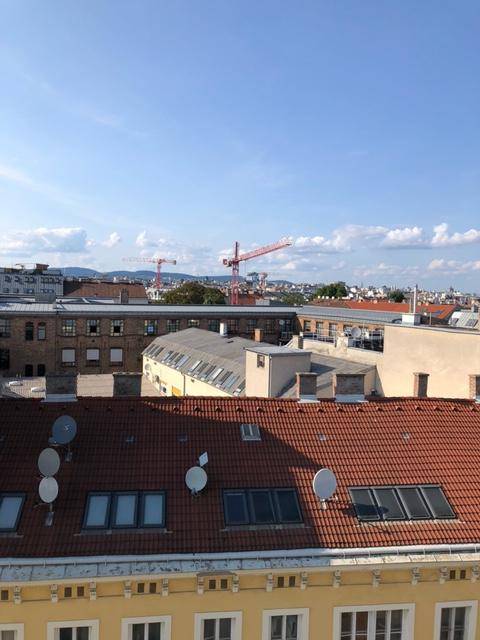 Weitblick über die Dächer der Stadt mit zahlreichen Gebäuden und Baukranen.