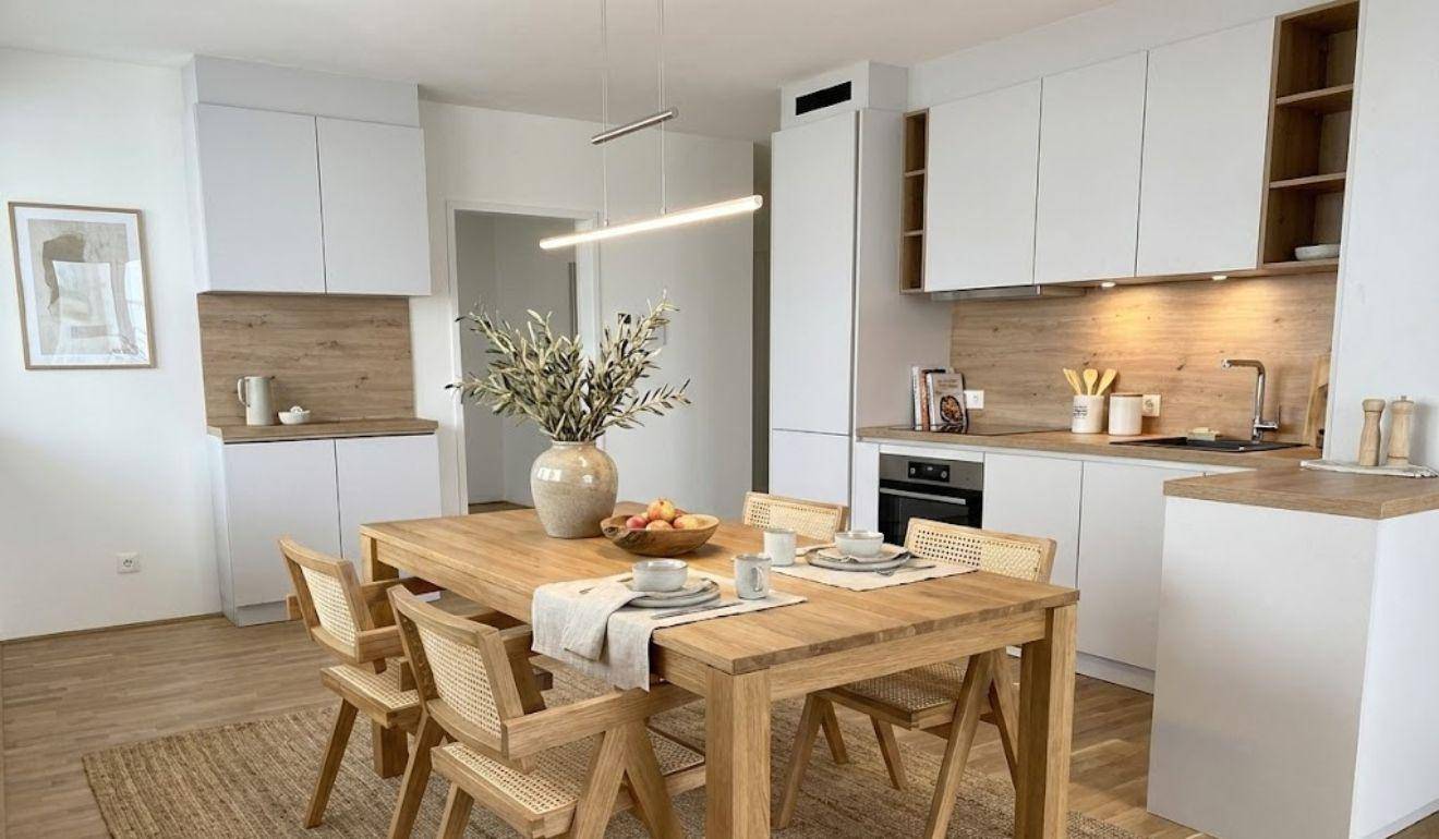 Offener Wohn-Essbereich mit moderner Küche, Holztisch und stilvoller Dekoration.
