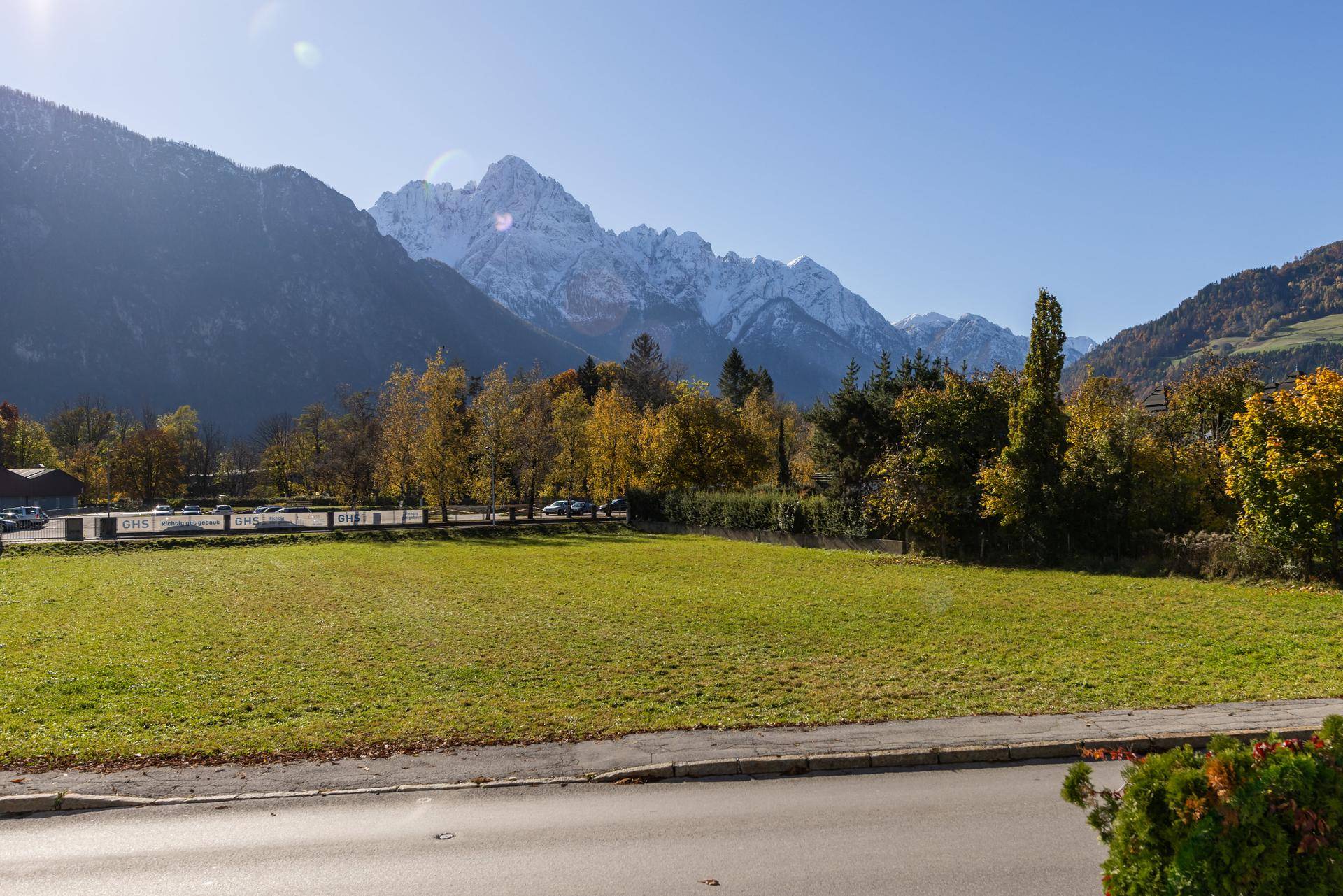 Weitläufige Grünfläche mit Blick auf die majestätischen schneebedeckten Berge im Hintergrund.
