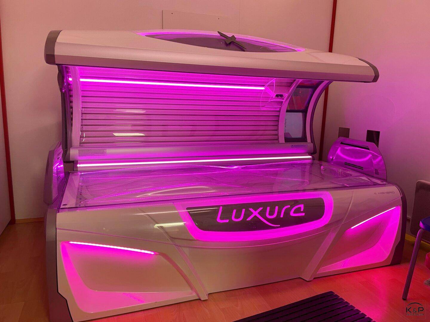 Modernes Solarium mit leuchtend pinker Beleuchtung in einem kommerziellen Raum.