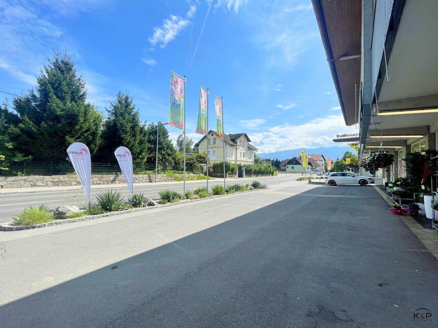 Blick auf die Straße mit Geschäften und Wohnhäusern in der Umgebung unter strahlend blauem Himmel.