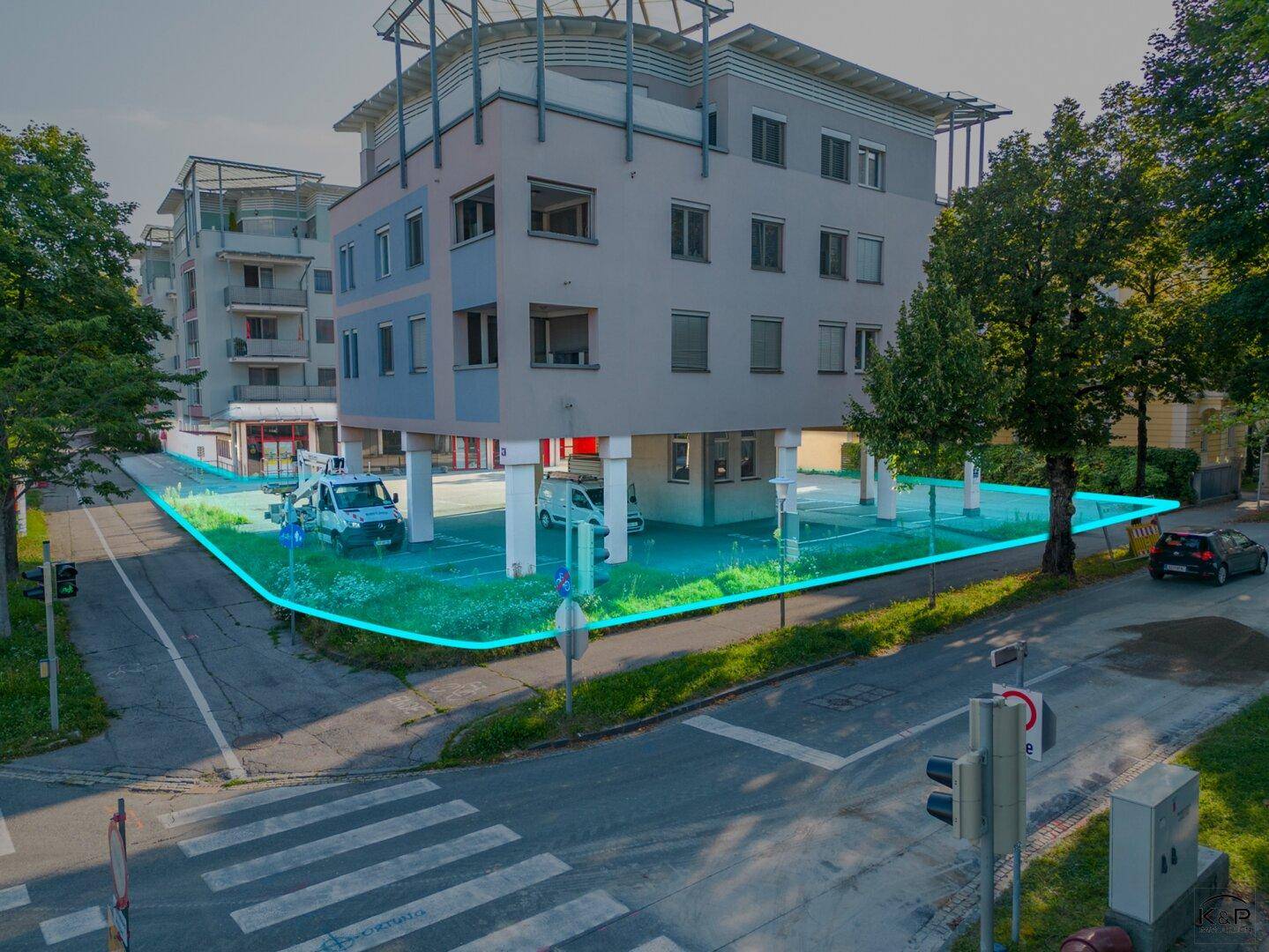 Ansicht des modernen Gebäudes von der Straße mit überdachten Parkplätzen im Erdgeschoss und umliegender Grünfläche.