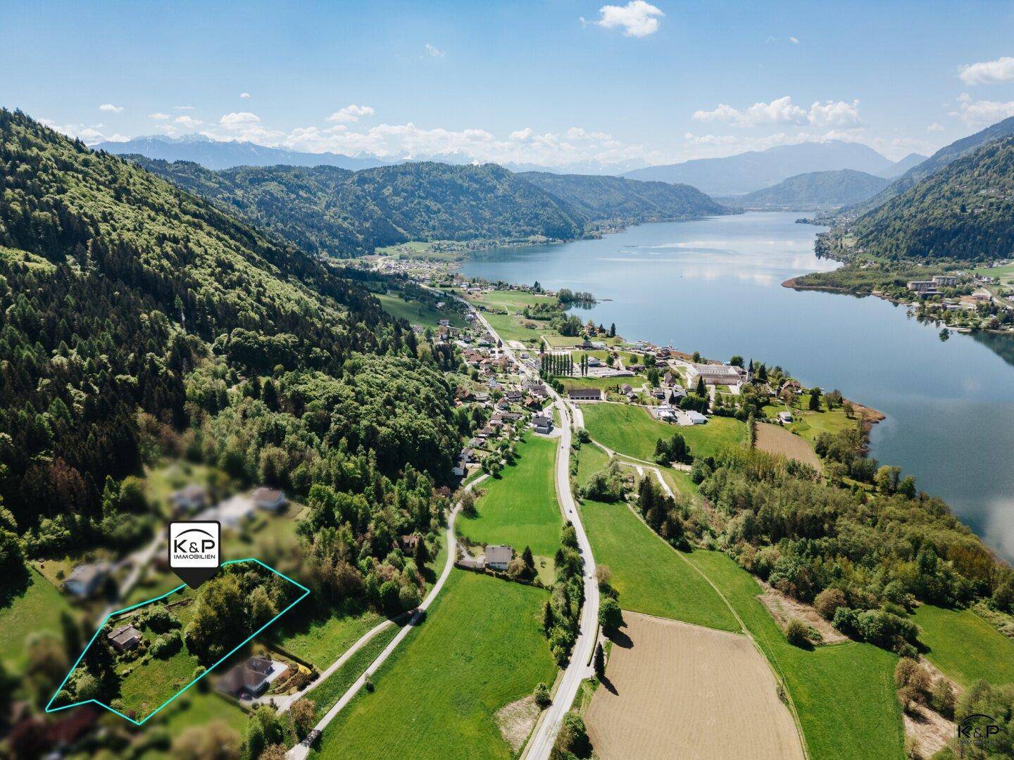 Luftaufnahme eines Sees und der umliegenden Landschaft mit einem markierten Grundstück.