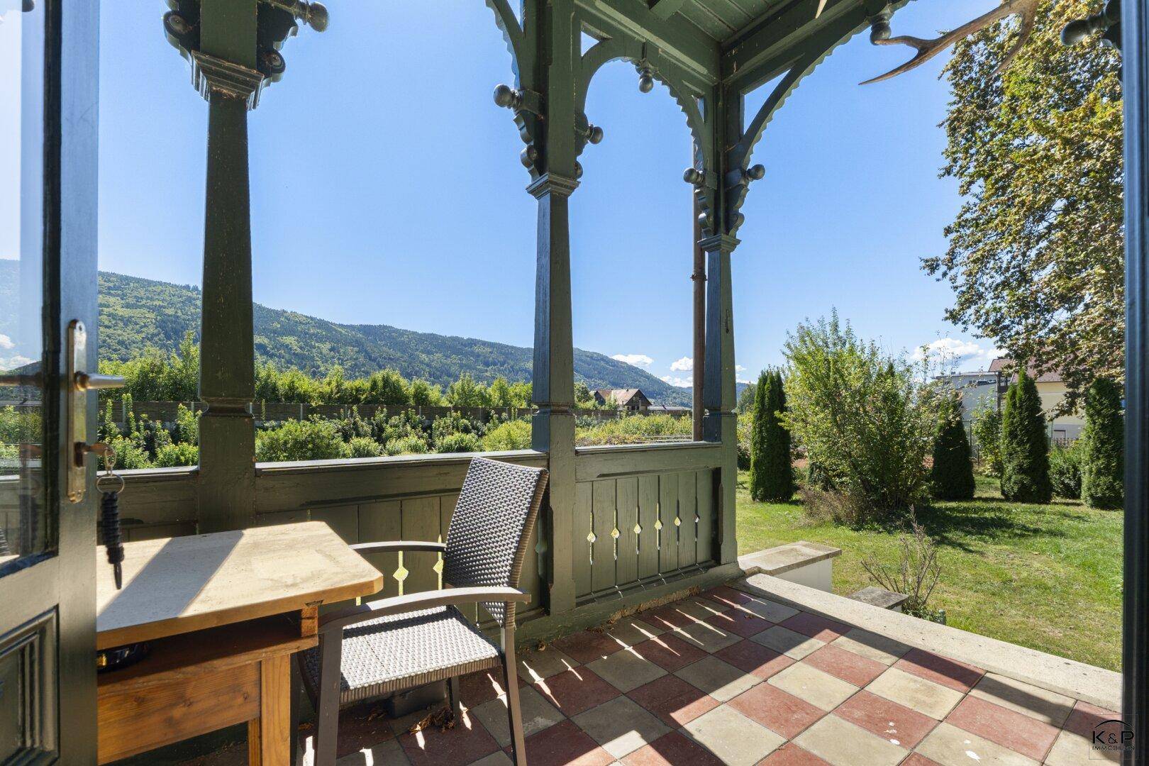 Gemütliche Terrasse mit kariertem Fliesenboden und Holzelementen, ideal für entspannte Stunden im Freien.